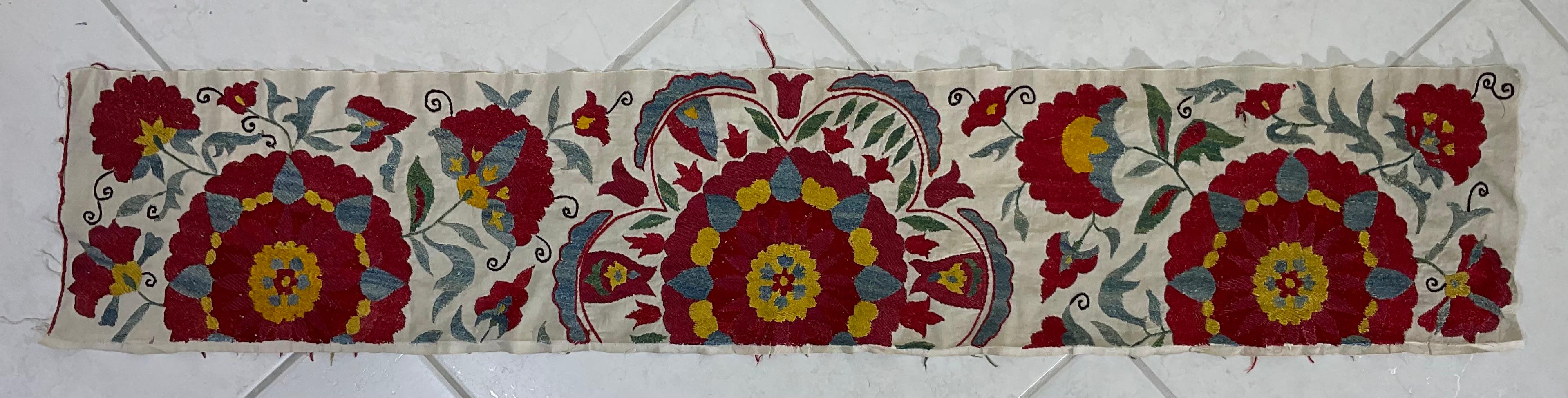 This vintage Suzani is a stunning example of Central Asian embroidery. Its intricate floral motifs and vibrant colors showcase the skill and artistry of its creator. It can be used as a wall hanging, throw, or tablecloth, adding a touch of elegance