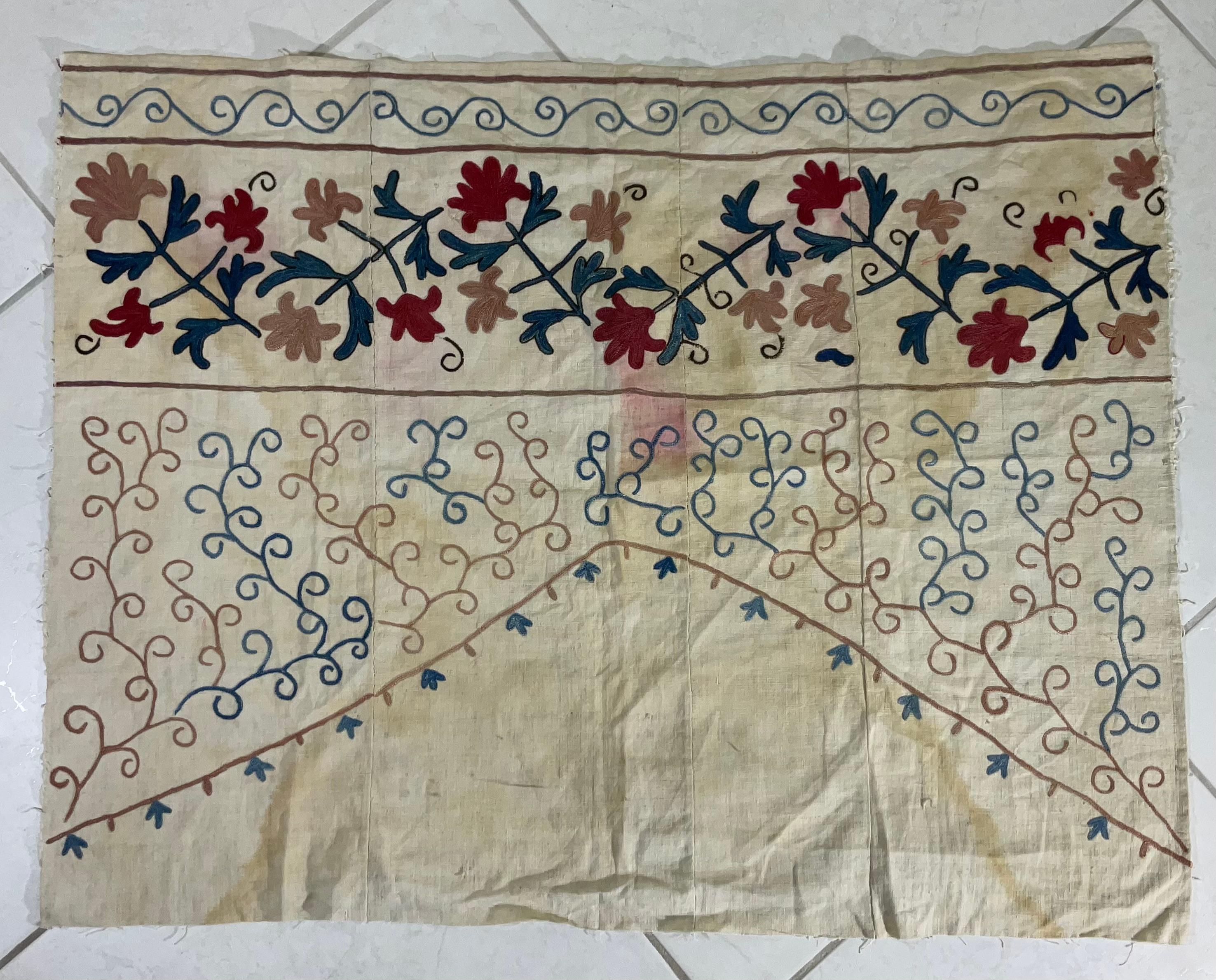 This antique Suzani is a beautiful example of Central Asian embroidery. Its intricate floral motifs and vibrant colors showcase the skill and artistry of its creator. It can be used as a wall hanging, throw, or tablecloth, adding a touch of elegance