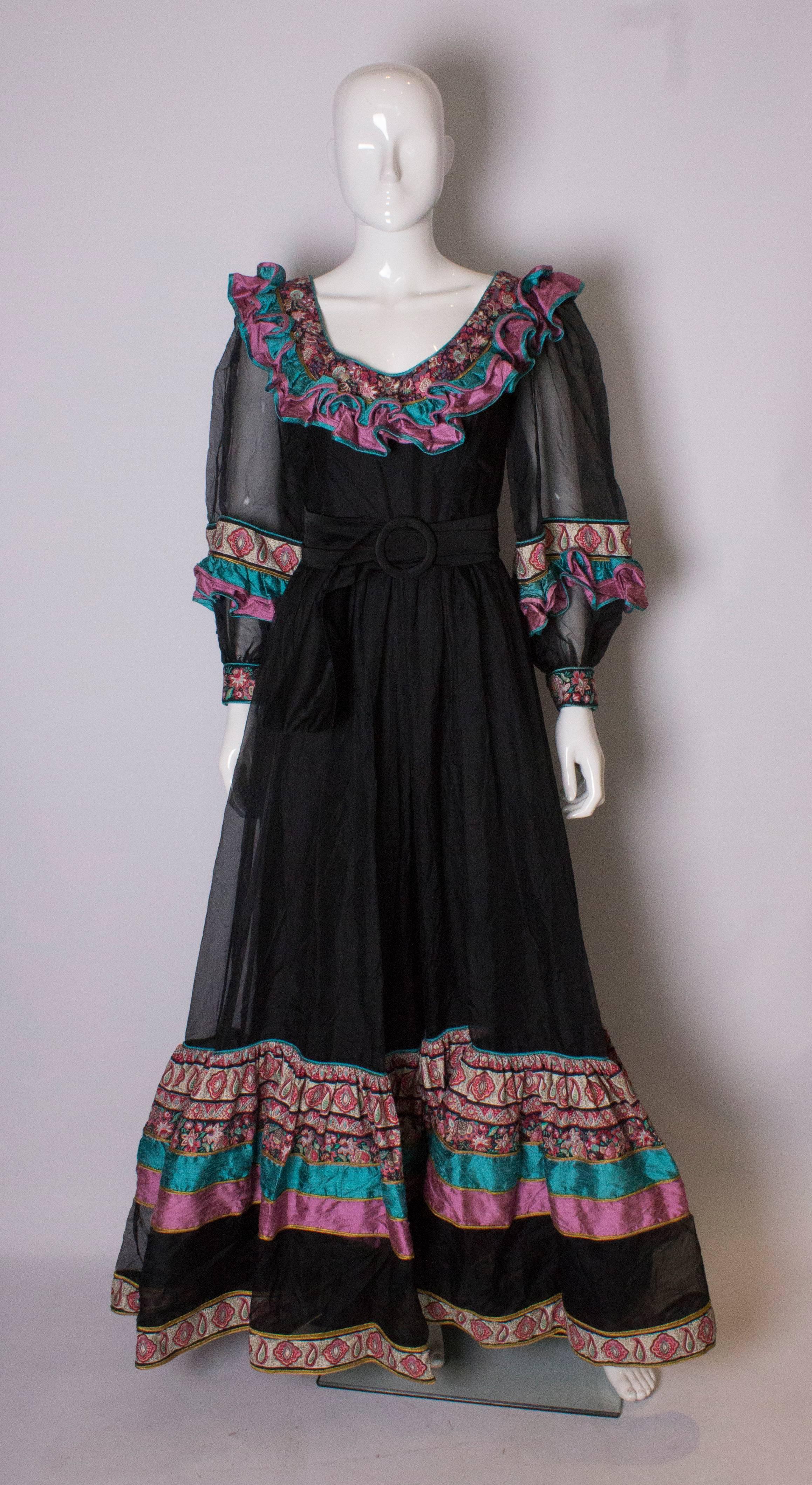  A stunning vintage gown by Regamus , London. The dress has a v neckline, with silk print frills on the neckline and hem. It has a central back zip, and silk underskirt.