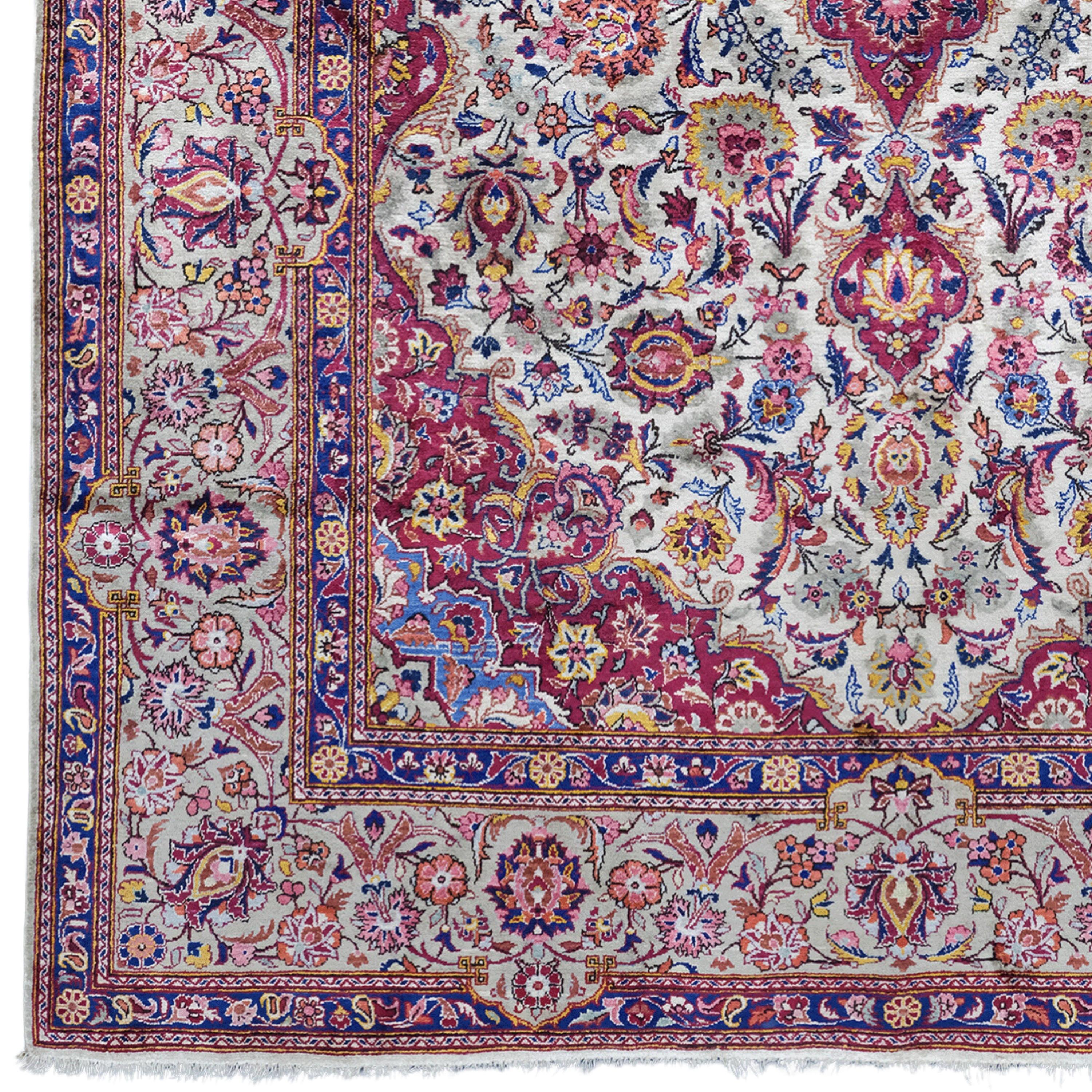 This mid-20th-century antique silk Keshan rug stands out for its rich colors, intricate pattern and hand-woven craftsmanship.

Pattern and Colors: This rug is decorated with an intricate pattern in deep shades of red and blue. Traditional Keshan