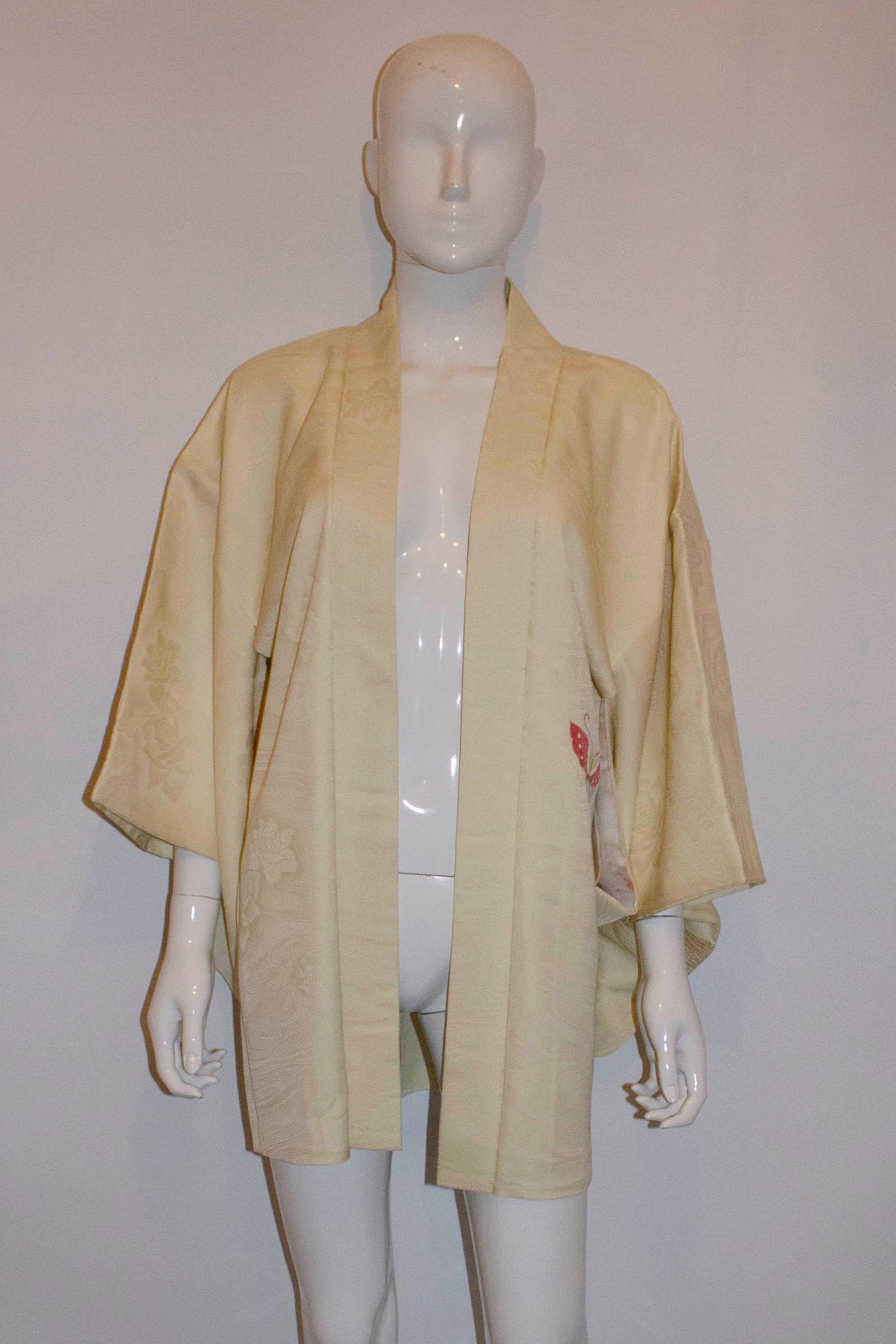 A pretty and easy to wear short silk kimono.  With a textured silk background the kimono has a colourful detail of butterflys with a floral design. Measurements: Bust up to 42'',length 32''.