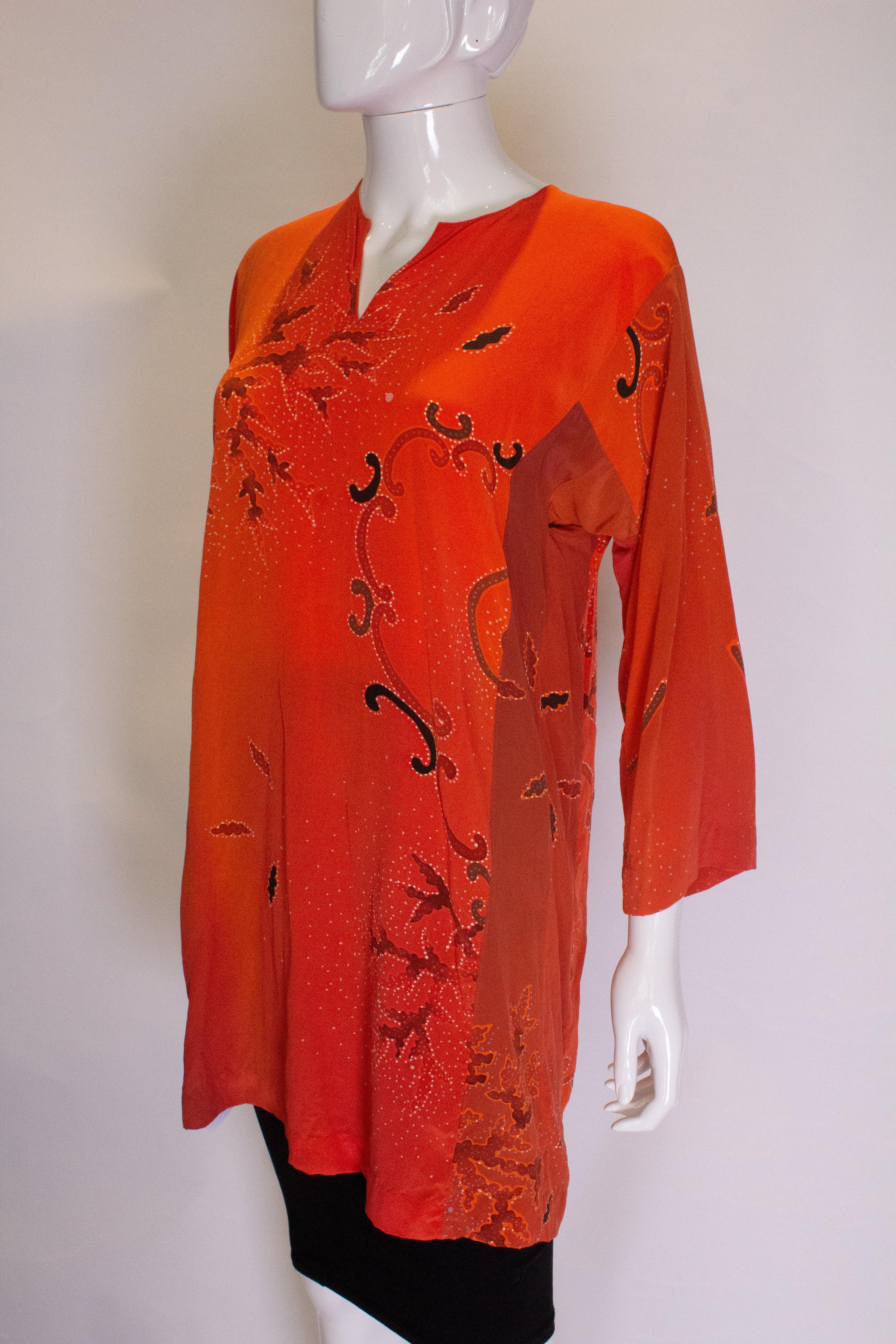  A great vintage mini dress/summer cover up.. The dress is in an orange , black and red print with a v neckline, and elbow length sleaves.