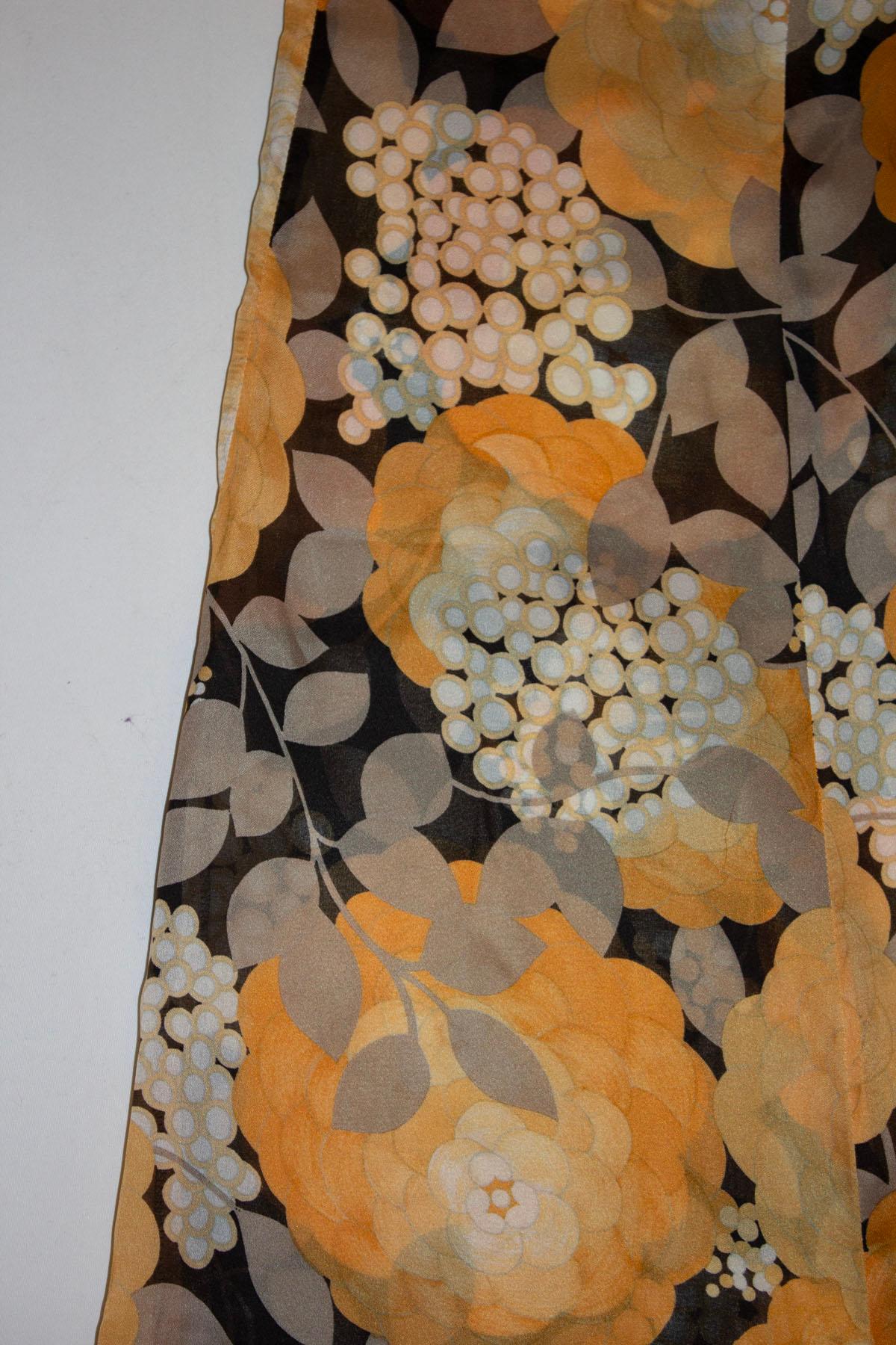  Un superbe pantalon en soie vintage, réalisé en France pour Bonwit Teller. Le pantalon présente un magnifique imprimé floral, en noir, orange et blanc.  Ils sont dotés d'une ouverture zippée au dos. Mesures : taille 26''', jambe intérieure 29''