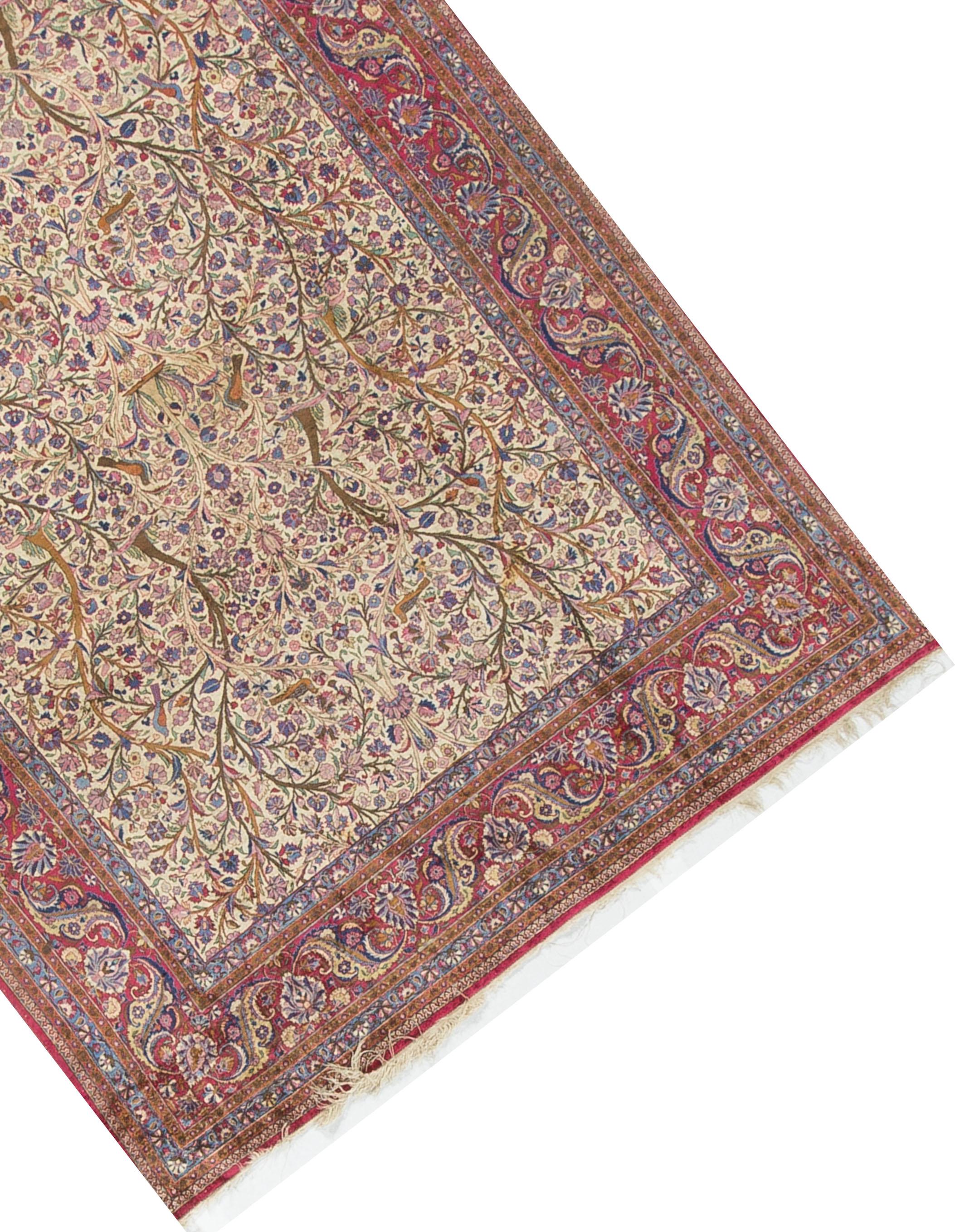 A vintage Persian silk Kashan, circa 1930. The soft ivory field filled with floral designs surrounded by a main border in reds and repeating the floral elements from the maim field. The multiple guard borders help create a soft and elegant look that