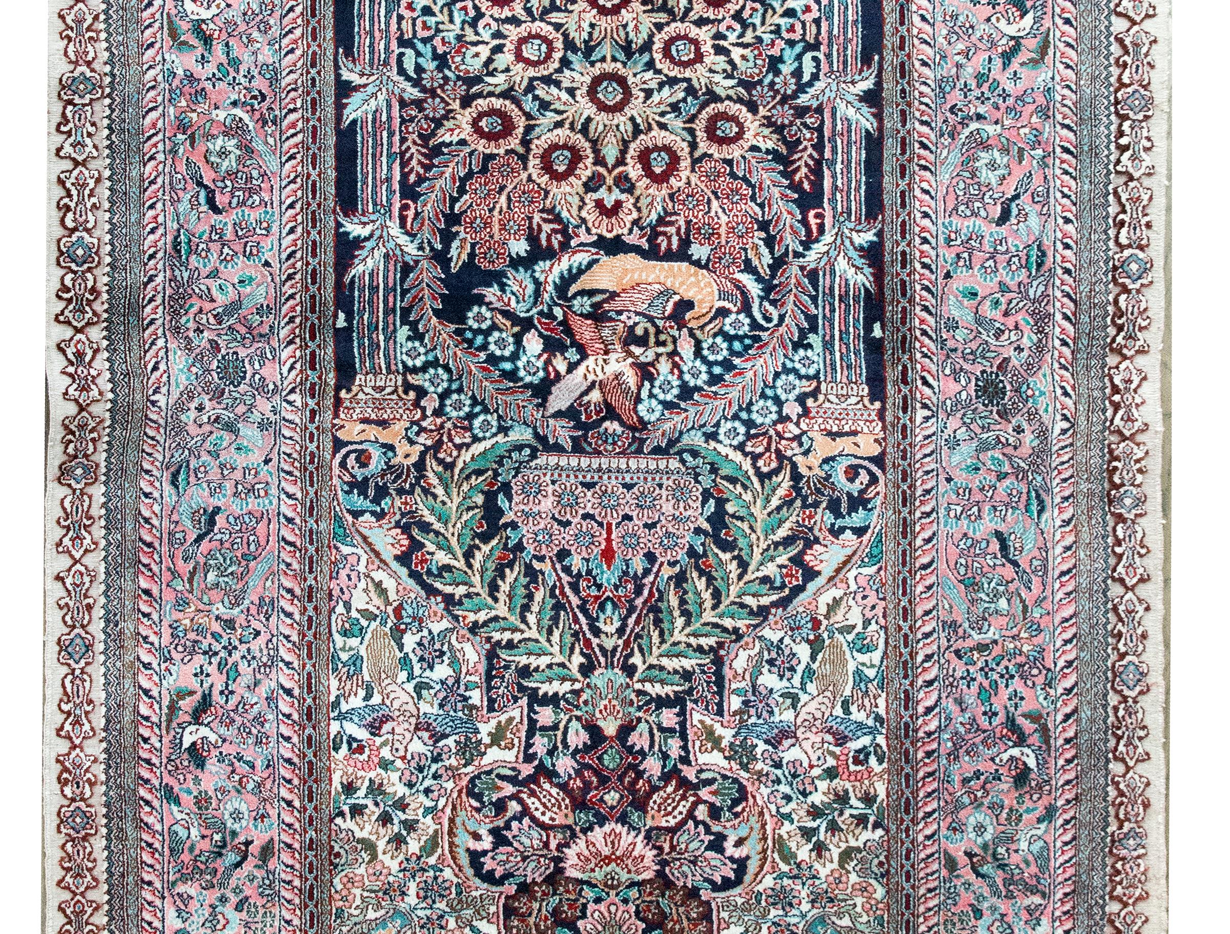 A stunning late 20th century Chinese hand-knotted silk prayer rug with the most elaborate mihrab decorated with with myriad flowers, vines, and birds, surrounded by a wide border with even more birds and flowers, and all woven in varying shades of