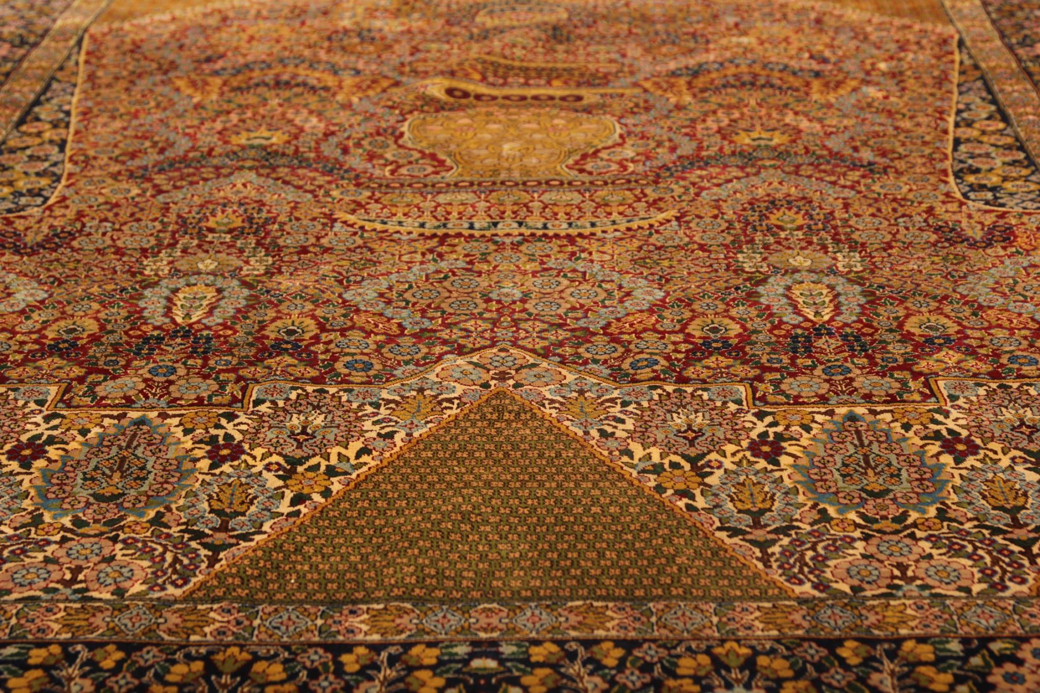 Transport yourself to a bygone era with our vintage silk rug, a testament to timeless elegance and craftsmanship. Hand-knotted with meticulous care, this exquisite carpet boasts a symphony of traditional motifs in rich shades of brown and gold,
