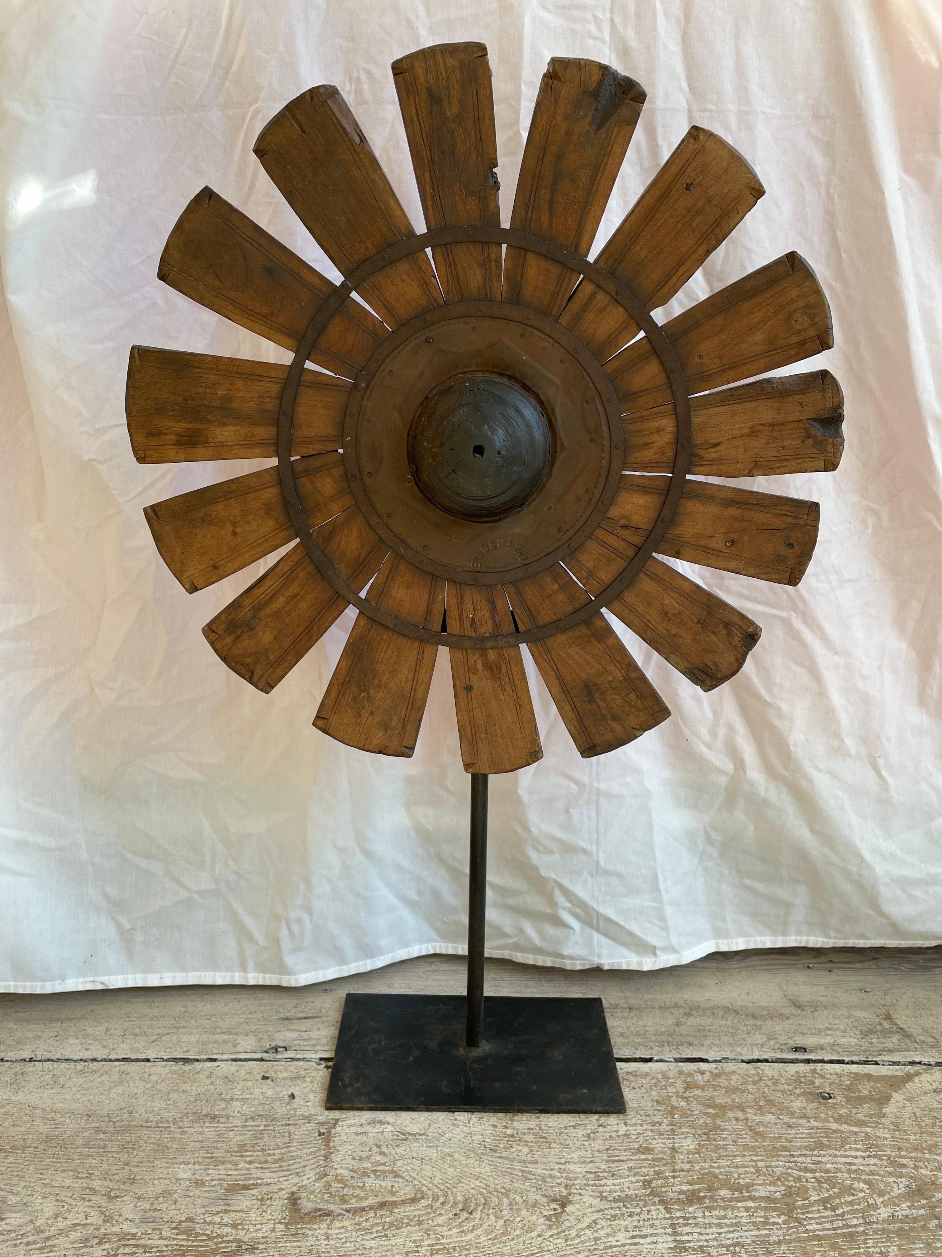 A fascinating vintage silk spinning wheel repurposed into a standing sculpture. It is teak and iron mounted on an iron rod and base. Has a wonderful textural and organic component, subtle floral imagery and history. The base is 10 inches x 6 inches.