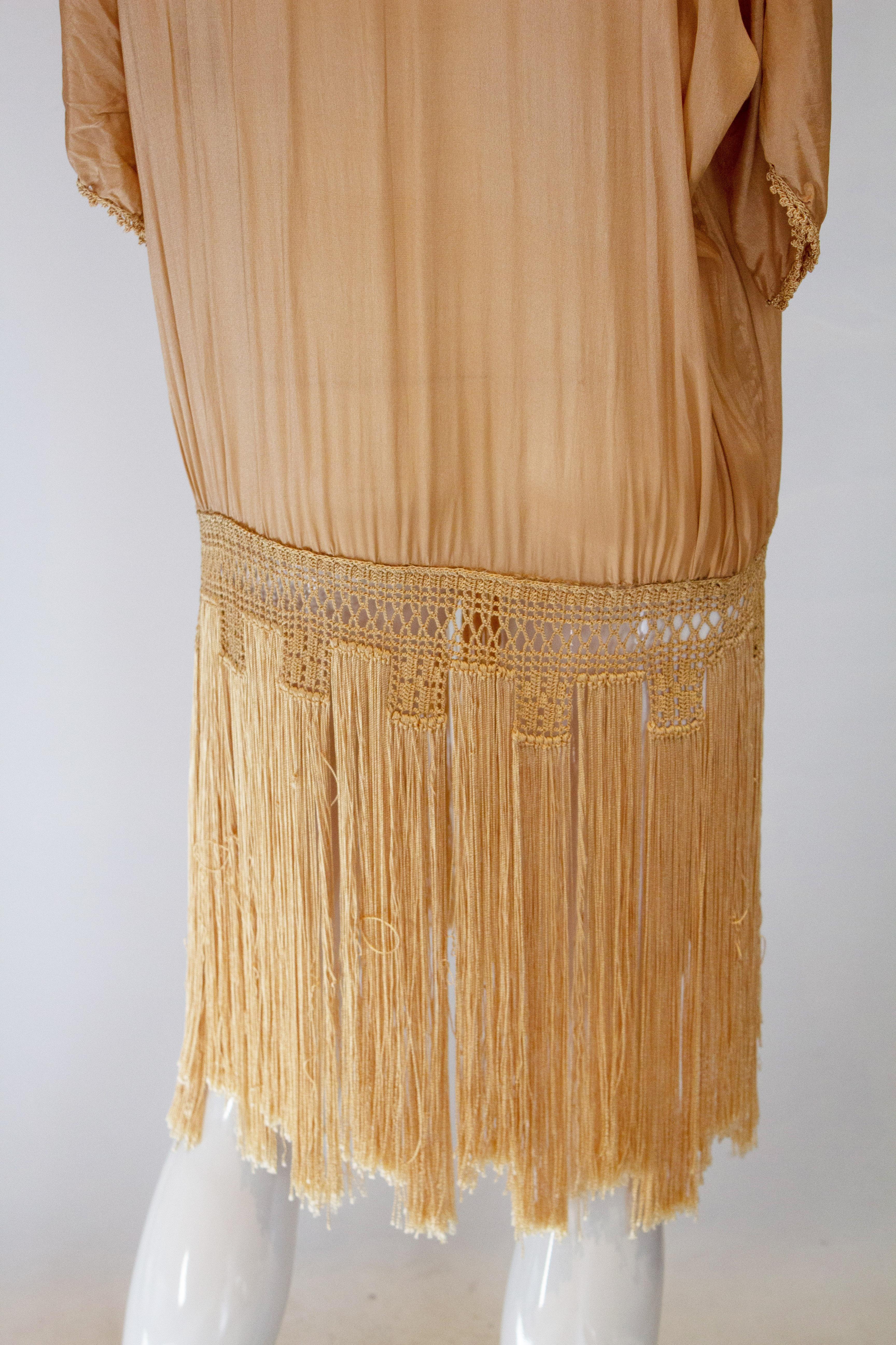 A chic caramel colour  vintage silk top, with wonderful fringe detail. The top has a v neckline, with trim along the neckline and edge of sleaves. The fringe and crochet detail at the hem is wonderful. Measurements: Bust up to 44'', length 40''