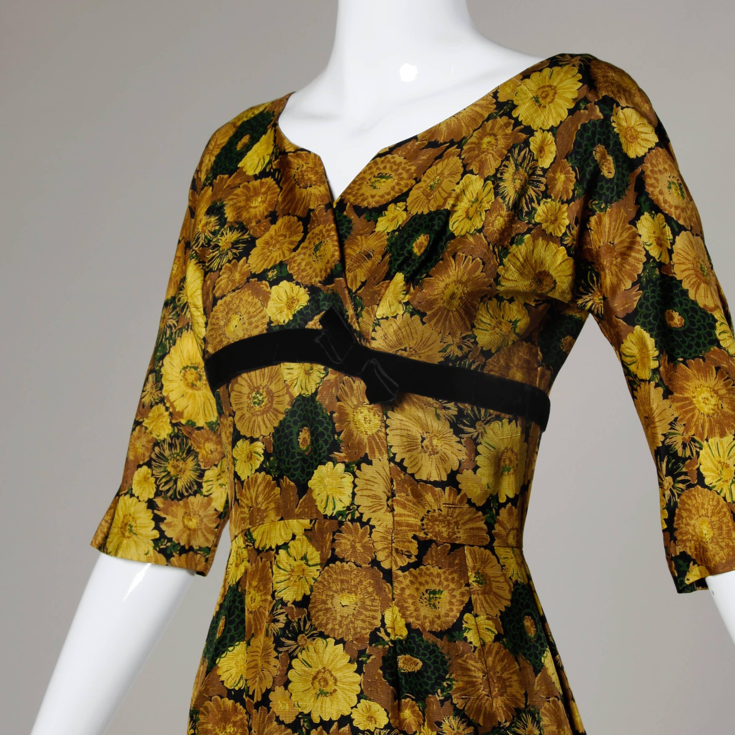 Elegant 1950s-1960s vintage floral printed silk cocktail dress with 3/4 length sleeves and hourglass silhouette. Fully lined with back metal zip and hook closure. Fits like a modern size small. The measurements are as follows: Bust: 36