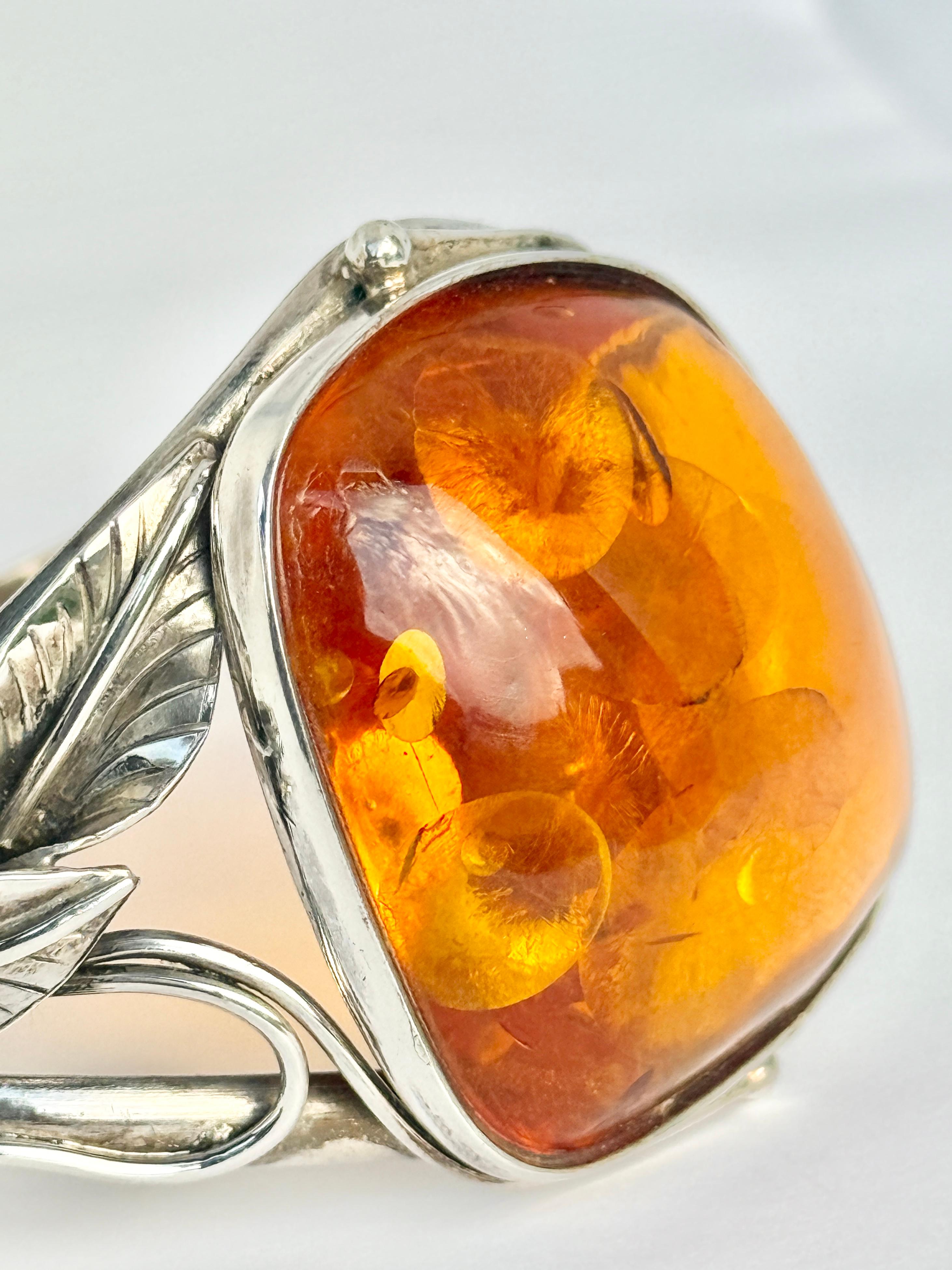 This stylish bracelet has gorgeously glossy amber set onto the decorative silver bangle. 

Inner Circumference: 19cm 
Stone Dimensions: 36x36mm 

Weight: 44.5g