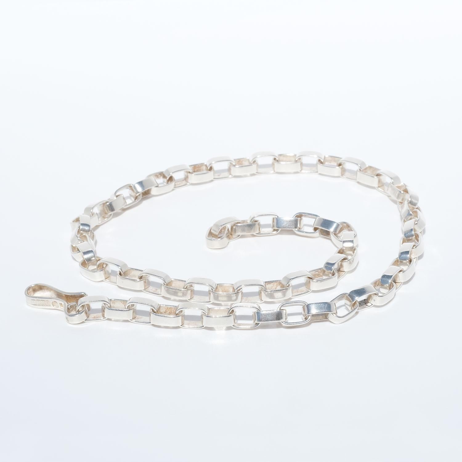 This sterling silver anchor chain necklace is made of silver rectangular links which are linked together. The links have a glossy surface and the necklace closes easily with a large hook.

This is a necklace that you can wear with any outfit and