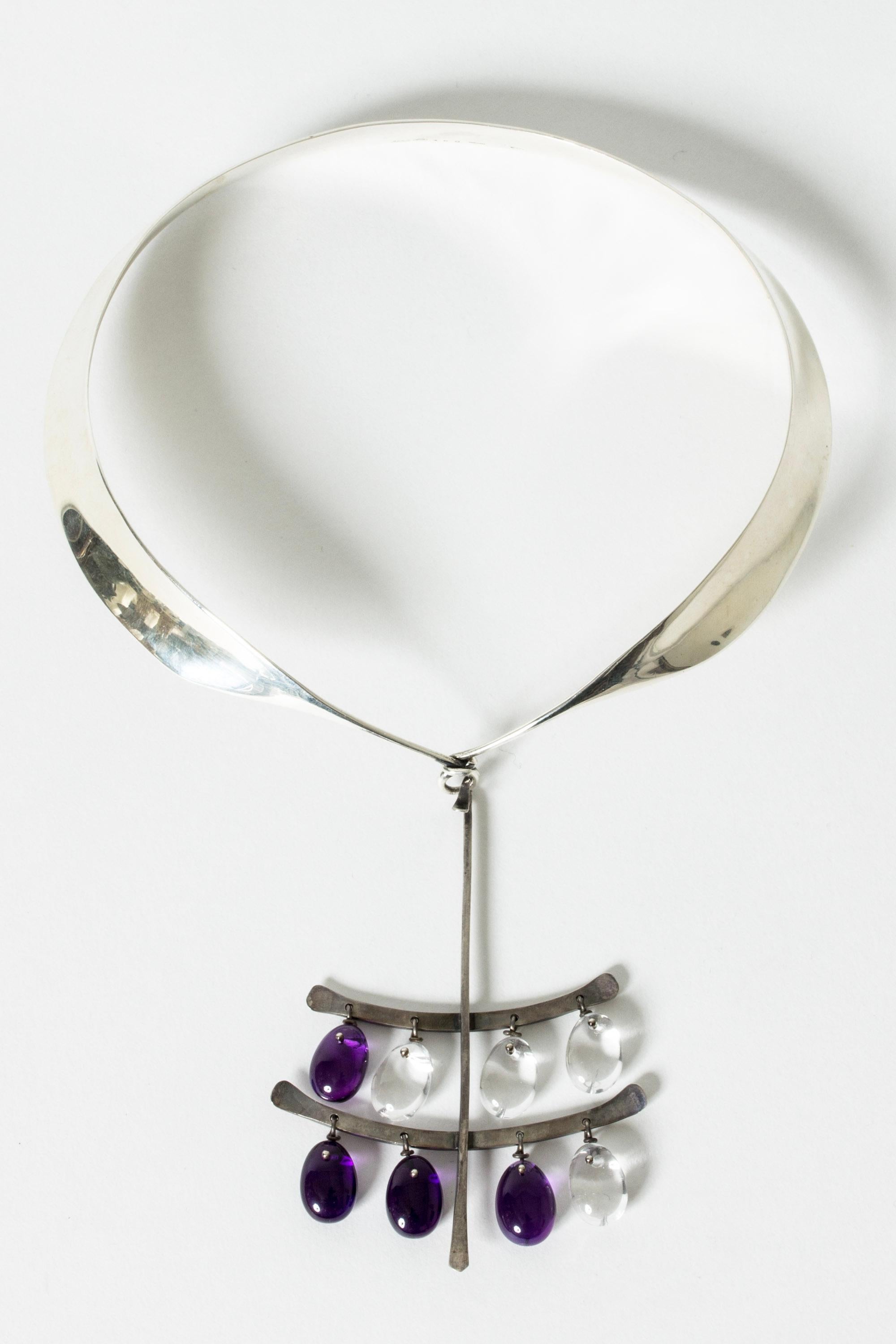 Silver neckring by Torun Bülow-Hübe with Torun’s signature “shawl” design. Stunning, large pendant with amethyst and rock crystal drops suspended on silver hooks. An exquisite collector’s piece.