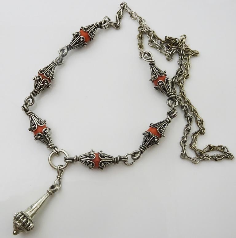 This unique one of a kind vintage necklace comes from North India or Afghanistan, 
composed of handmade elements that hug Coral Beads.
The Centre Piece is a cone , bell shaped element,
Made in Acid Tested coin Silver (.800)
25 inches long 55 cm
The