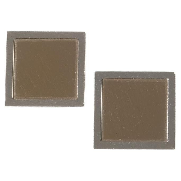 Ces boutons de manchette vintage présentent un design carré avec un centre en argent doré encadré par des bords en argent poli, créant un contraste saisissant. La partie dorée apporte une lumière chaude et raffinée, tandis que la bordure argentée