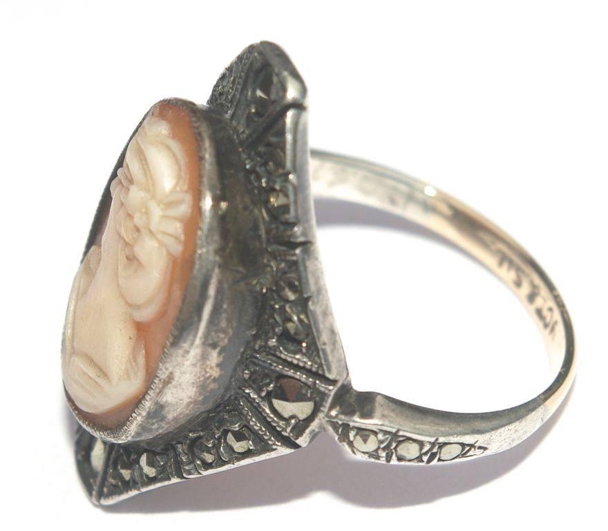 Beautiful and detailed hand carved shell cameo set in a silver surround with marcasites, ring size UK O, US 7 (inside diameter 1.8cm, .7 inch). The cameo measures 1.6cm, .63 inch by 1.15cm, .45 inch. The band is part 9ct gold and part silver, and is