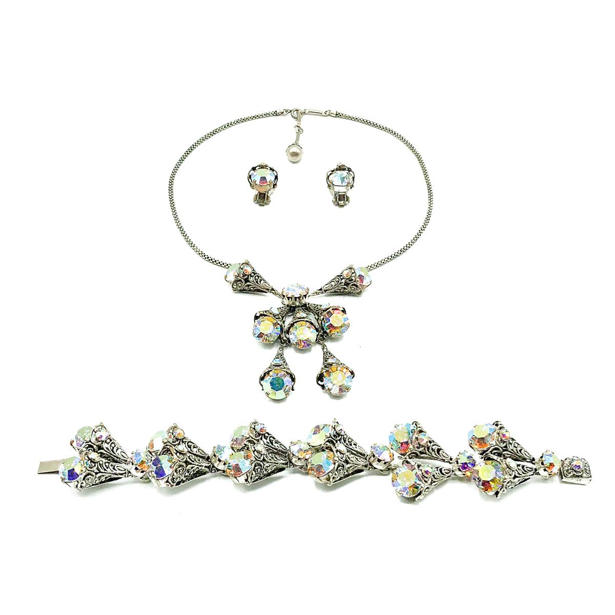 A divine and wonderfully feminine Vintage Aurora Borealis Necklace Suite from the 1950s. Comprising necklace, bracelet and earrings designed around a theme of filigree cones claw set with large, vibrant rainbow crystals . Crafted in silvertone metal