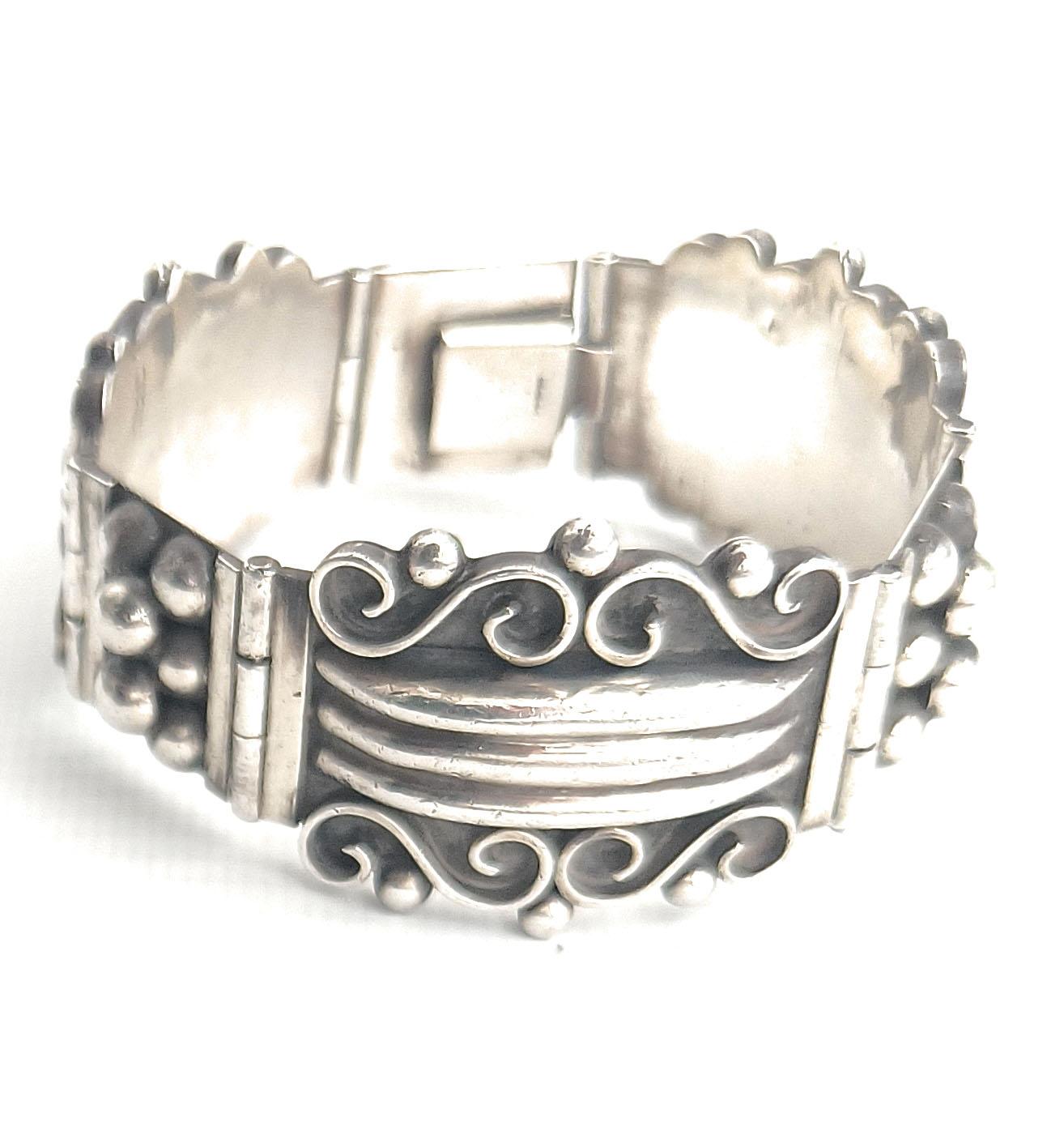  

Uno splendido bracciale d'argento d'epoca da collezione  realizzato a Taxco, in Messico, e risalente agli anni Settanta. Questo pezzo, molto dettagliato, presenta un disegno tradizionale di ispirazione azteca a segmenti collegati tra loro. 