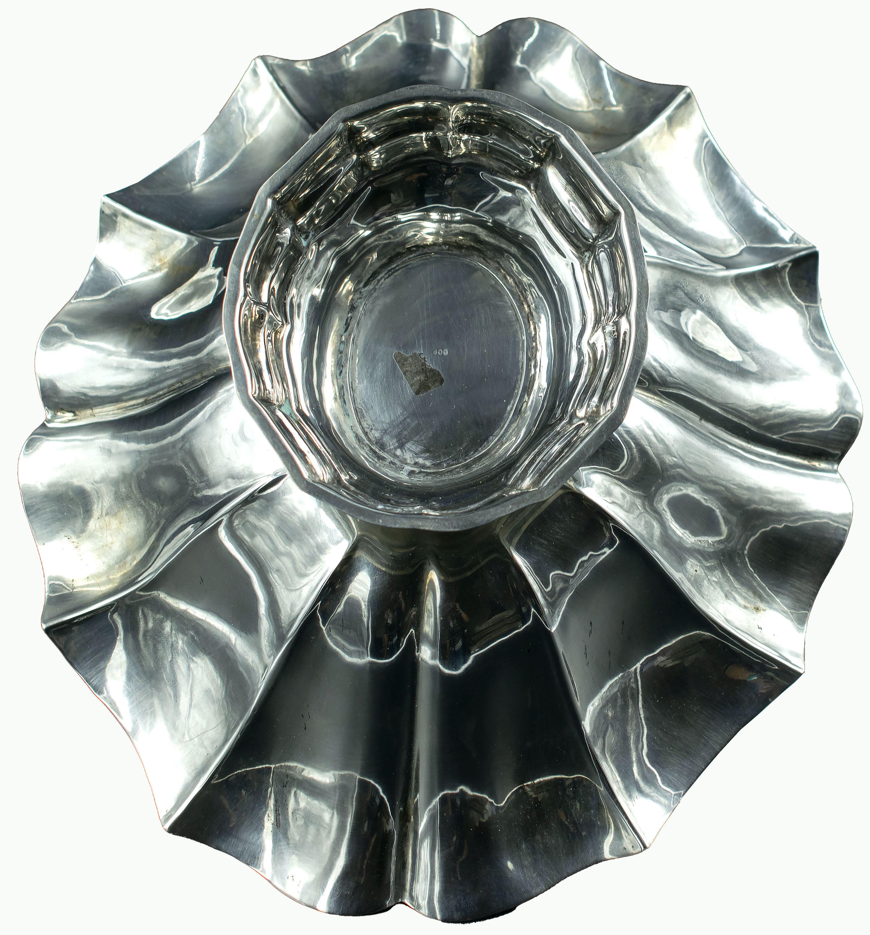 Silver centerpiece is a precious decorative object realized in the mid-20th century.

A very elegant silver centerpiece with wavy edges.

Supported by a circular base.