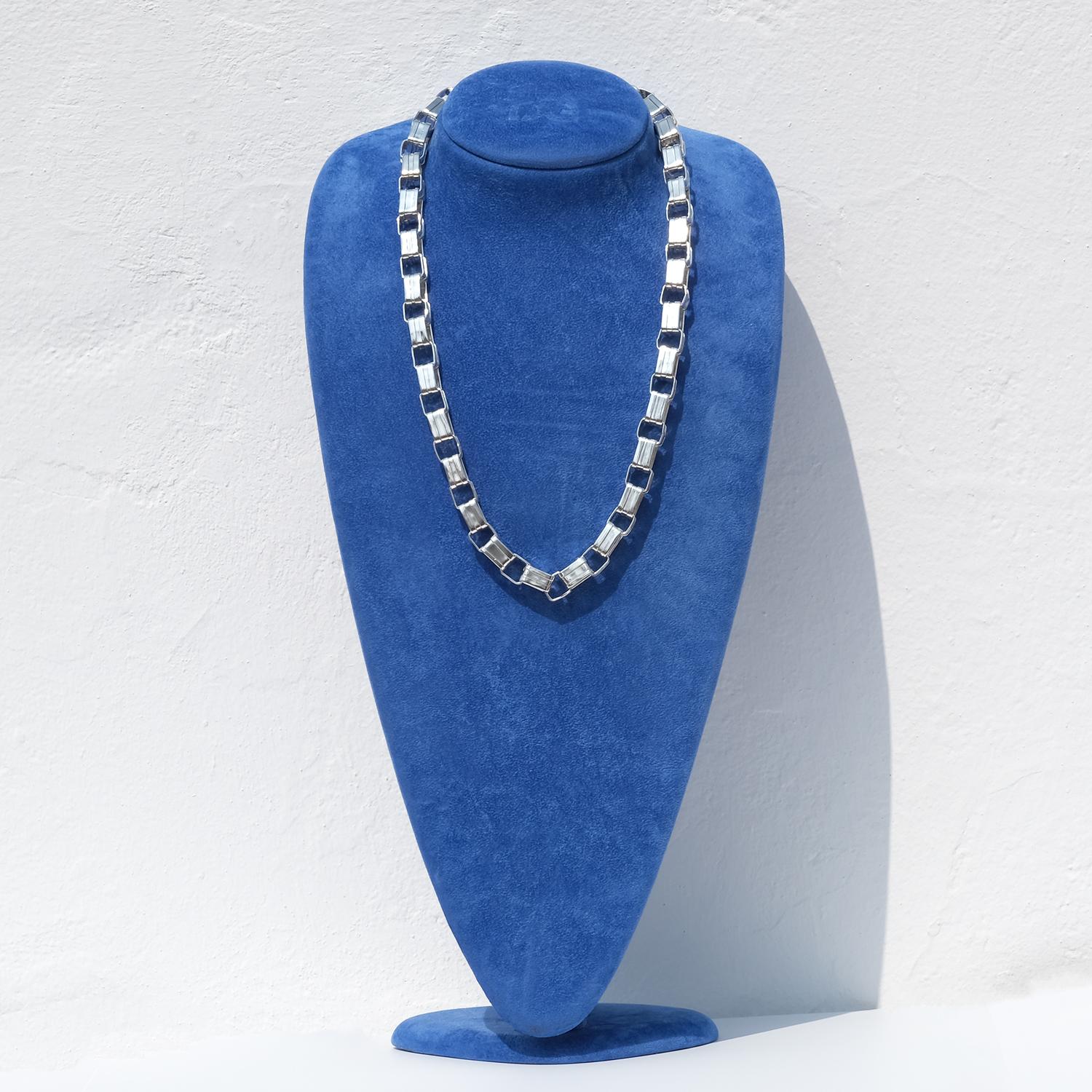 This sculptural sterling silver necklace is composed of repeating rectangular links in an alternating rhythm—one slightly shorter, one slightly longer—creating a subtle yet distinct pattern. Each link has a flat, polished surface with sharp edges