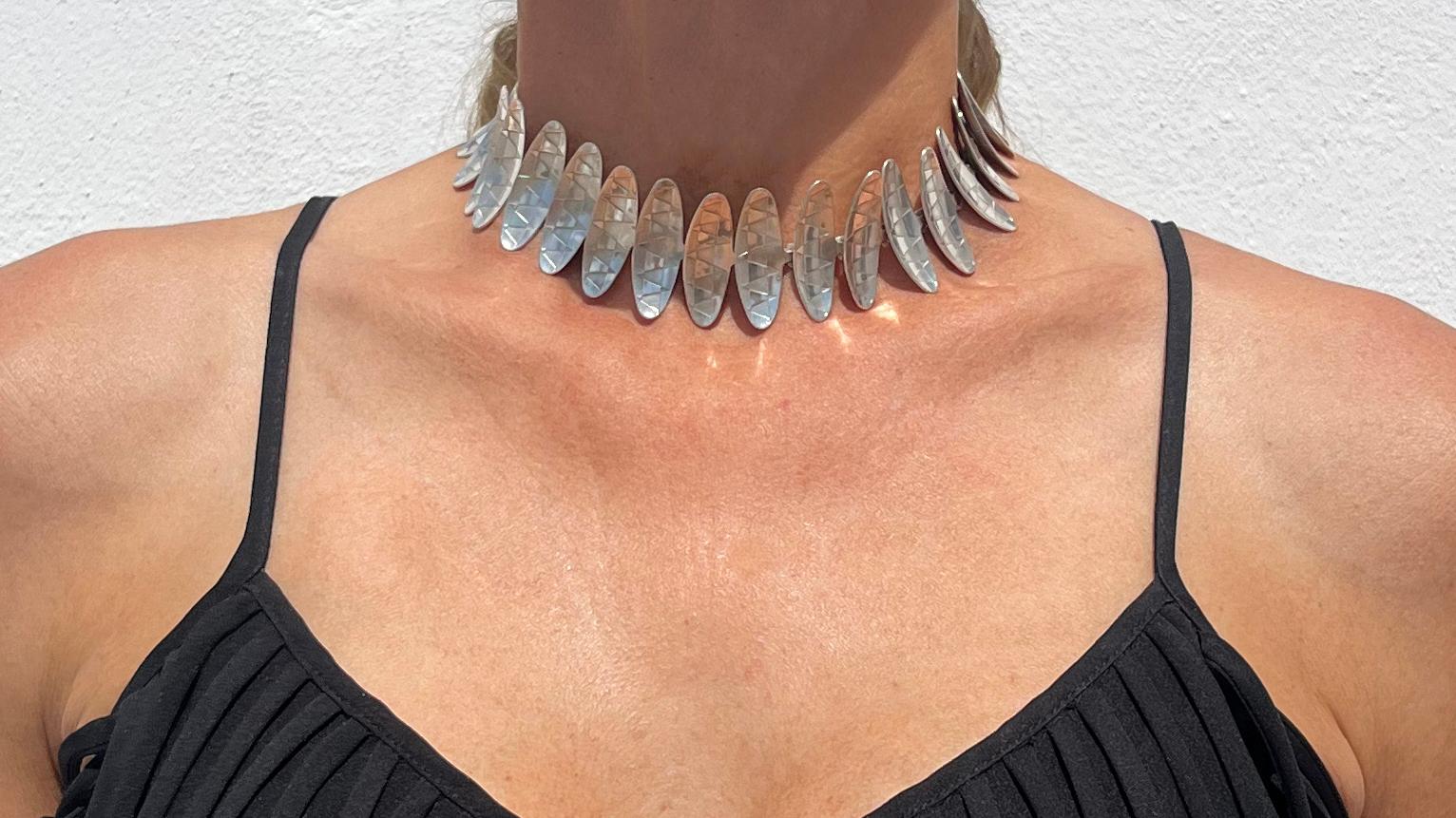 This sterling silver necklace are made out of something that looks like silver patterned shields. The shields are placed together with simple hooks and the necklace also closes easily with one.

The necklace is a so called choker, meaning a necklace