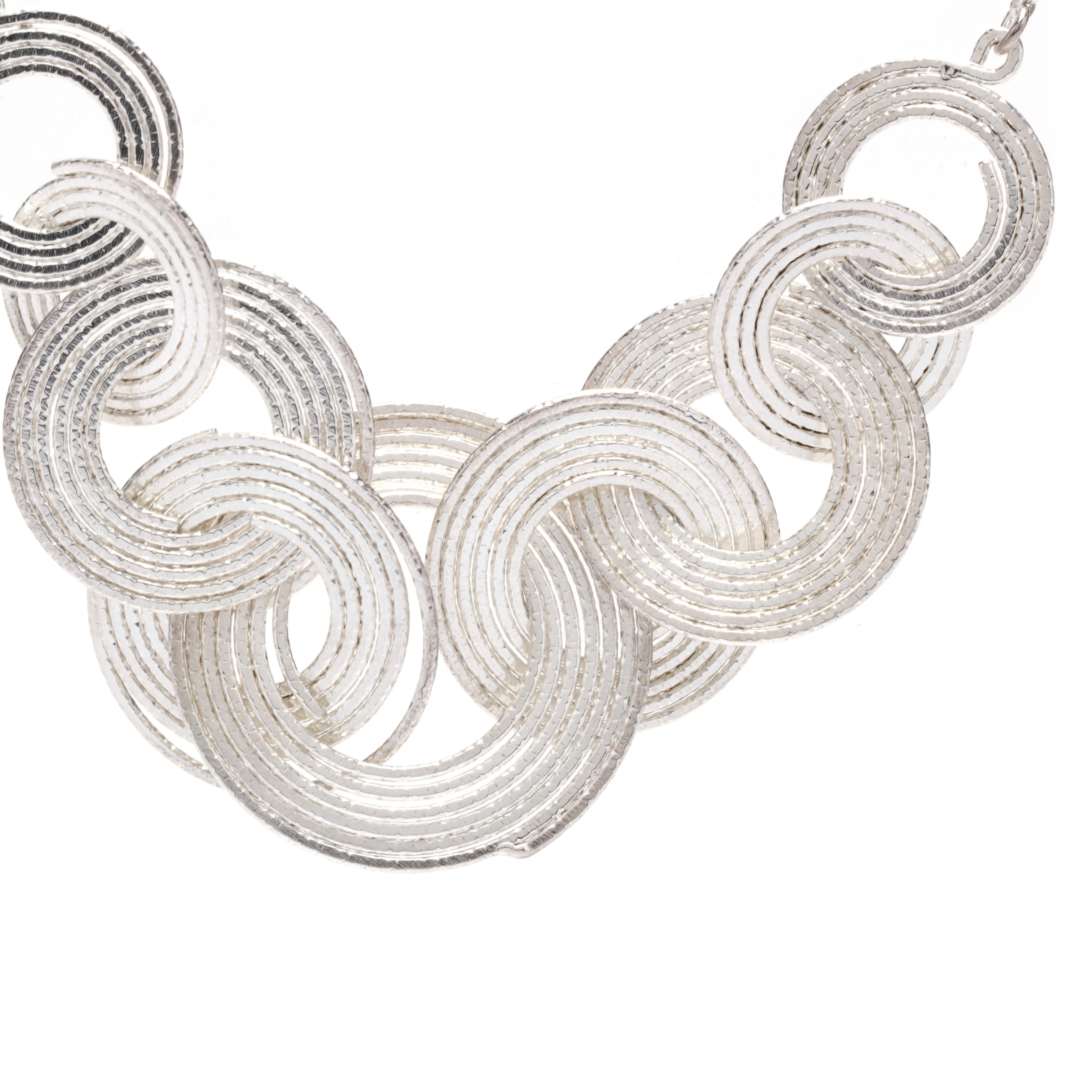 A sterling silver multi-circle necklace. This sparkle necklace features multi-size interlocking circles suspended from a thin cable chain with a lobster clasp.

Length: 18 in.

Chain Width: 1.65 mm

Pendant Width: 1 in.

Weight: 16.1 grams

Stamps: