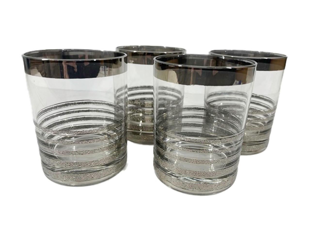 Set of 4 Mid-Century Modern rocks glasses having a smooth silver band at the rim and 5 graduated, textured silver bands on the lower half.