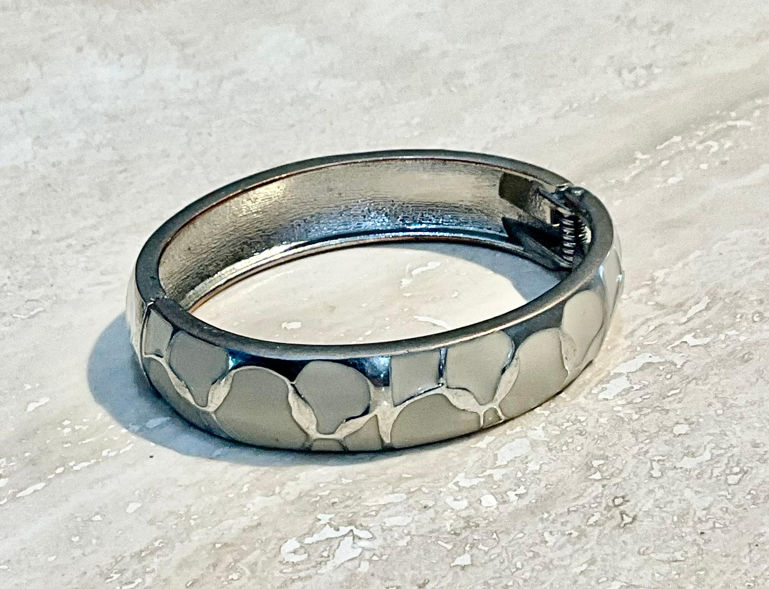 Il bracciale Clamper in argento e smalto vintage è un gioiello straordinario che combina il fascino senza tempo dell'argento con gli accenti vivaci e colorati dello smalto. Questi bracciali sono molto apprezzati per la loro abilità artigianale, per