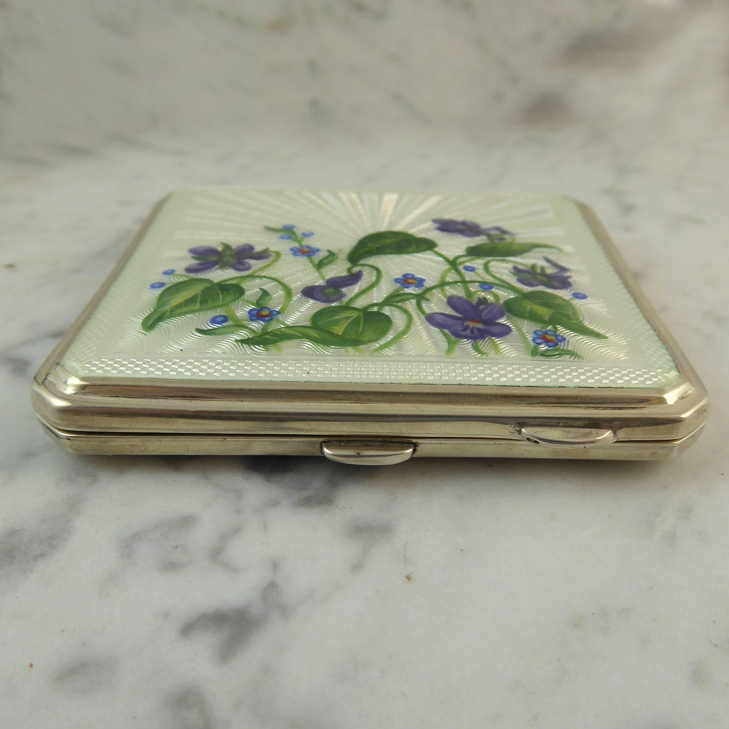 A beautiful vintage powder compact hallmarked in the Coronation Year of Queen Elizabeth II and with the stamp of new monarch incorporated into the hallmark.  The front of the compact is decorated with  spray of Dog Violet and Forget-Me-Nots against