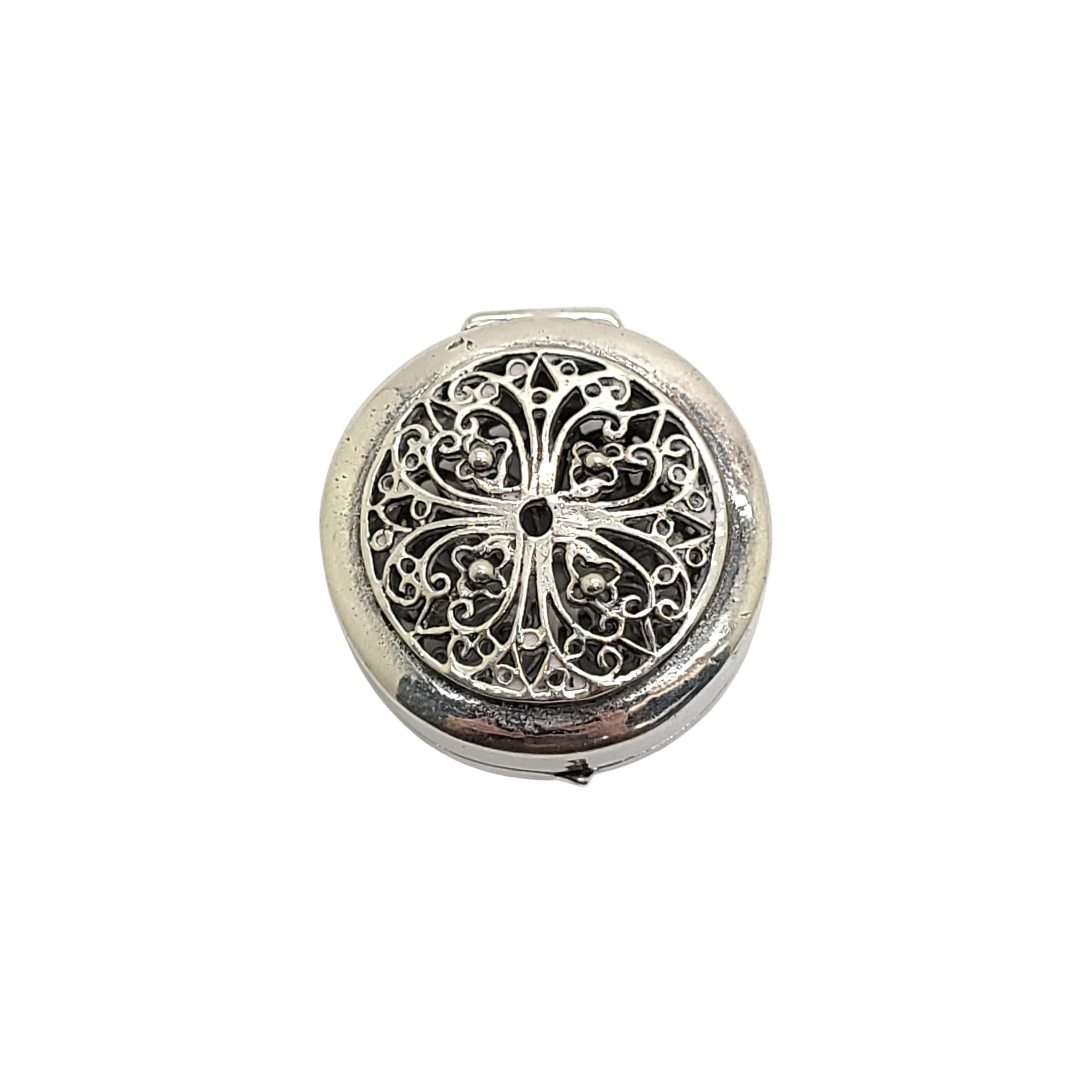 Kleine runde Filigrandose aus Silber.

Es könnte als Pillendose oder als kleine dekorative Dose verwendet werden, die auf Reisen für Parfüm und Düfte verwendet wurde. Schönes offenes filigranes Design auf beiden Seiten. Kein Monogramm.

Misst ca. 1
