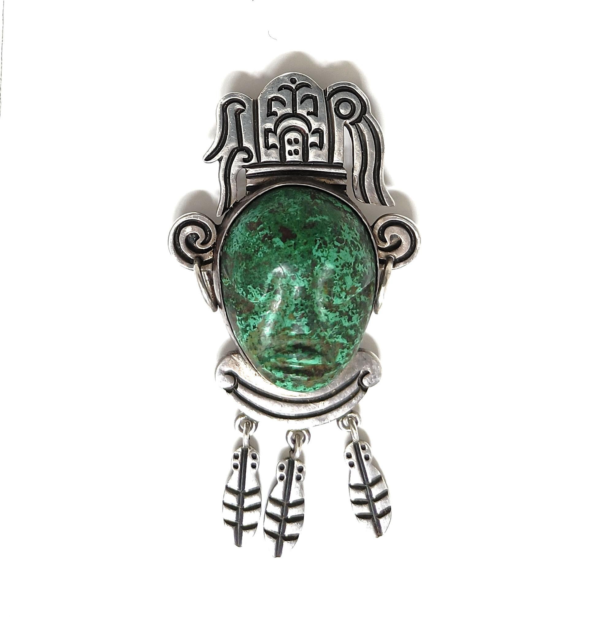 Spilla d'epoca in argento con pietra verde dal design azteco Taxco Mexico 

Un'attraente spilla vintage in argento da collezione con pietra verde intagliata e maschera di ispirazione Pre-Columbian,  realizzato a Taxco, in Messico, e risalente agli
