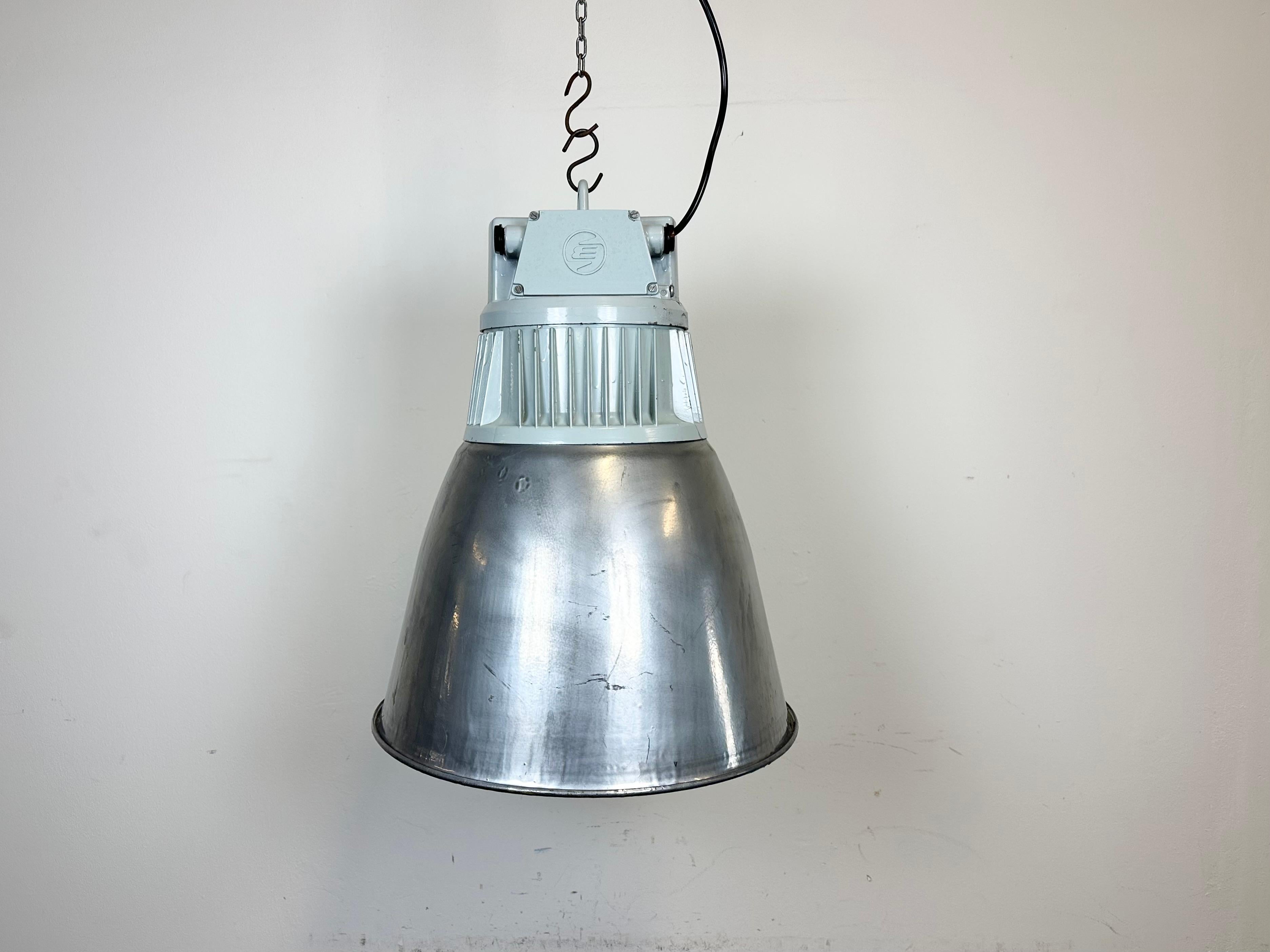 Industrielle Fabrikhallenleuchte
- Hergestellt von Elektrosvit
- Produziert in der ehemaligen Tschechoslowakei in den 1970er Jahren
- Eisen silberfarbener Schirm
- Graue Aluminiumgussplatte
- Gewicht: 5,8 kg
- Durchmesser : 43 cm
- Neue