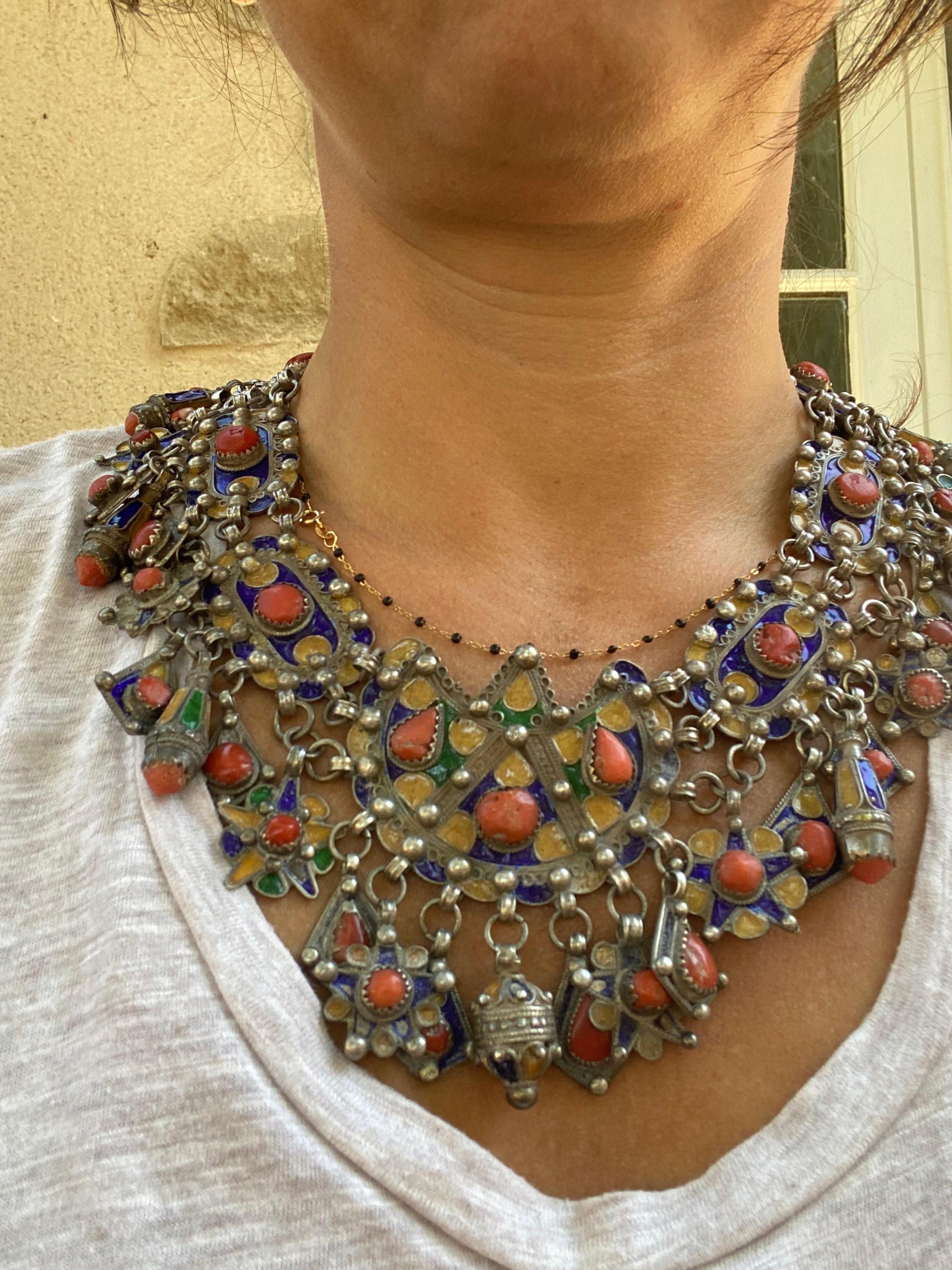 Delightful Kabyle necklace in silver and coral Algeria Beni Yenni People dating from first half of the 20 th century. It is made up of several articulated elements, each adorned with polychrome enamels and charms. The closure is a simple hook.
