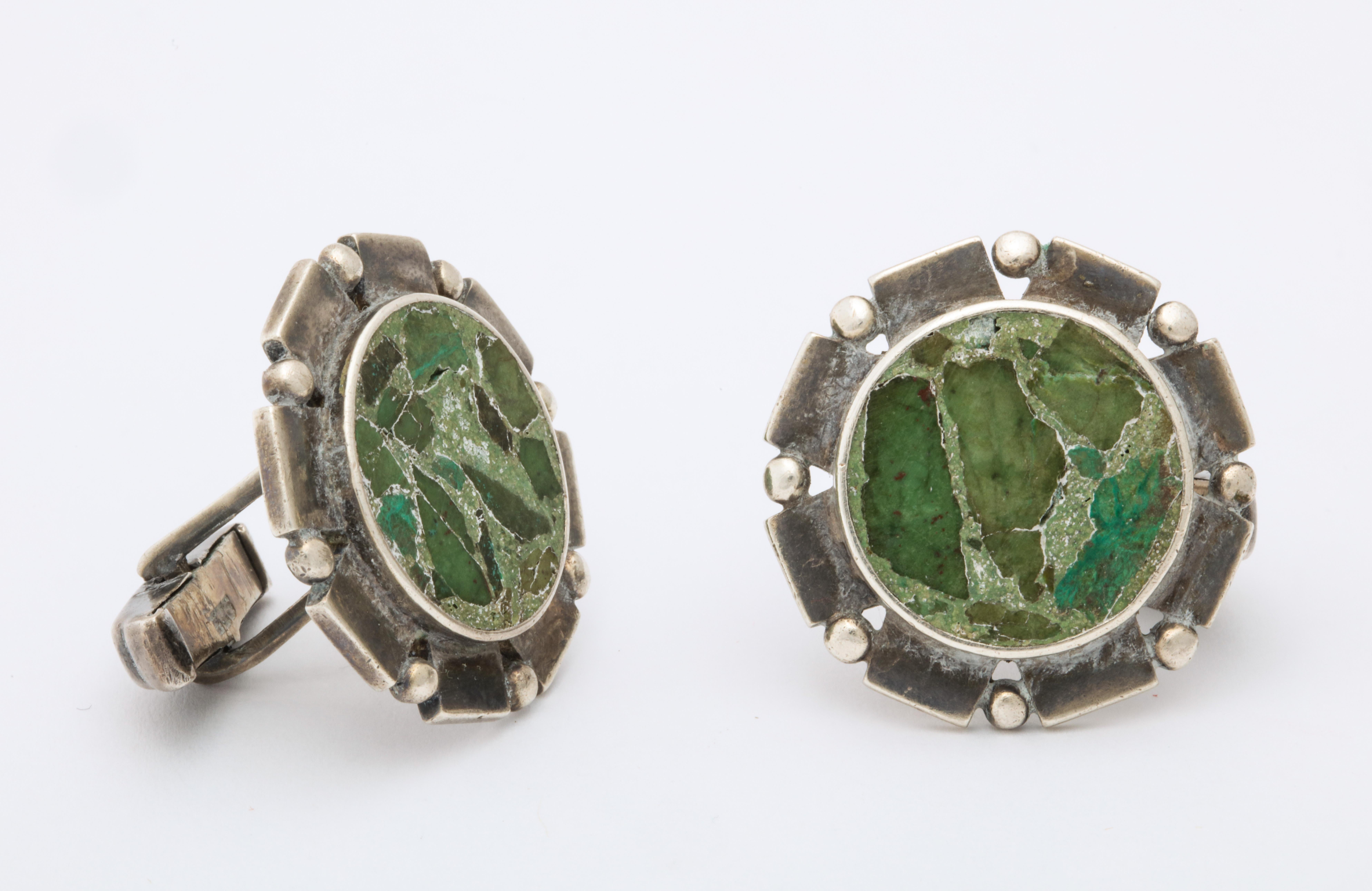 A stylish pair of sterling and agate cufflinks made by the major Mexican studio jewelry designers at the time when he bolstered the fine art of Mexican jewelry.  Hand made in the mid 20th century,  these links are shaped like a wheel. Around the