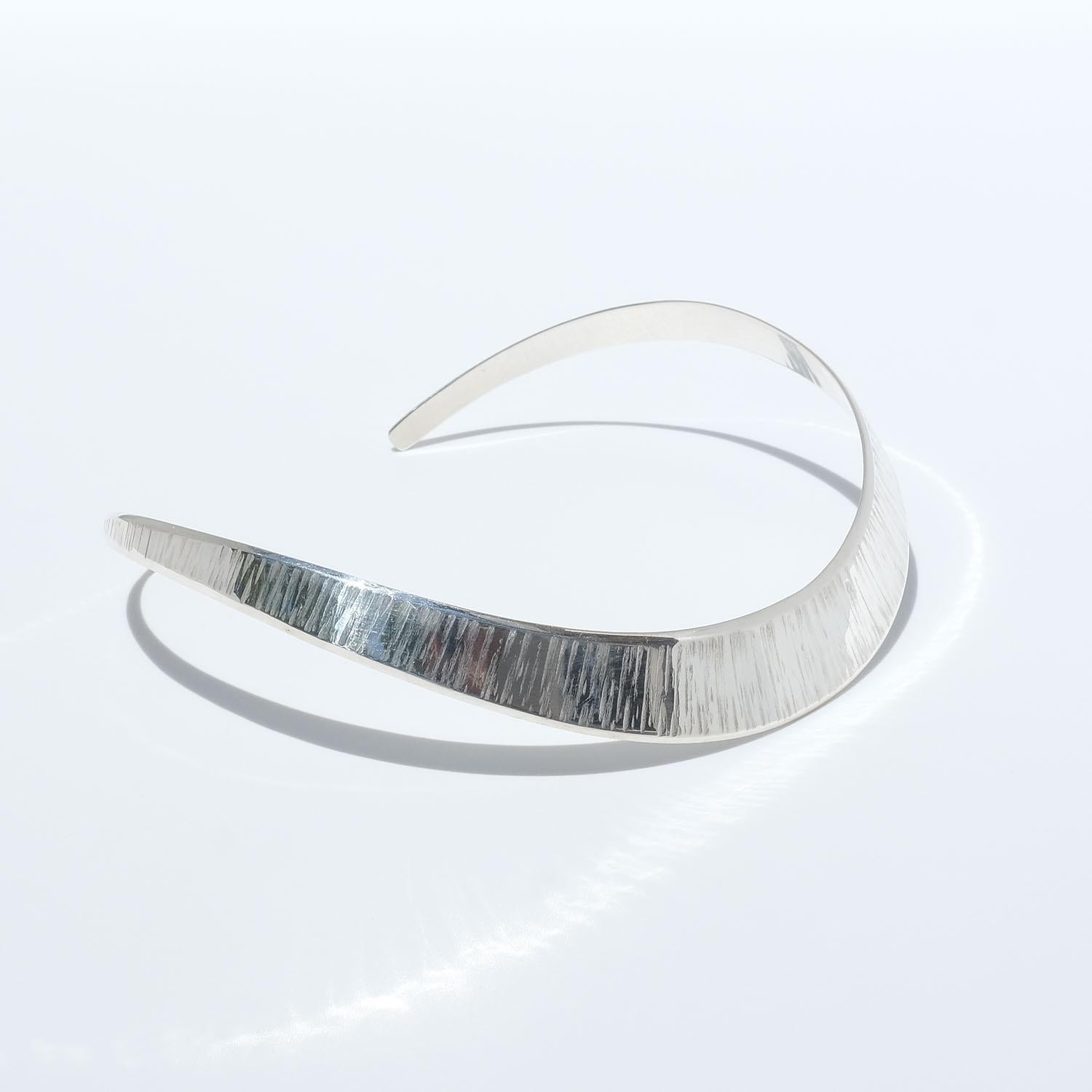 This fixed sterling silver neck ring has a beautiful patterned surface. When holding it you can feel the quality and genuine handcraft.

The neck ring is simple but yet elegant and it will complement your outfit in a splendid way whether it is an