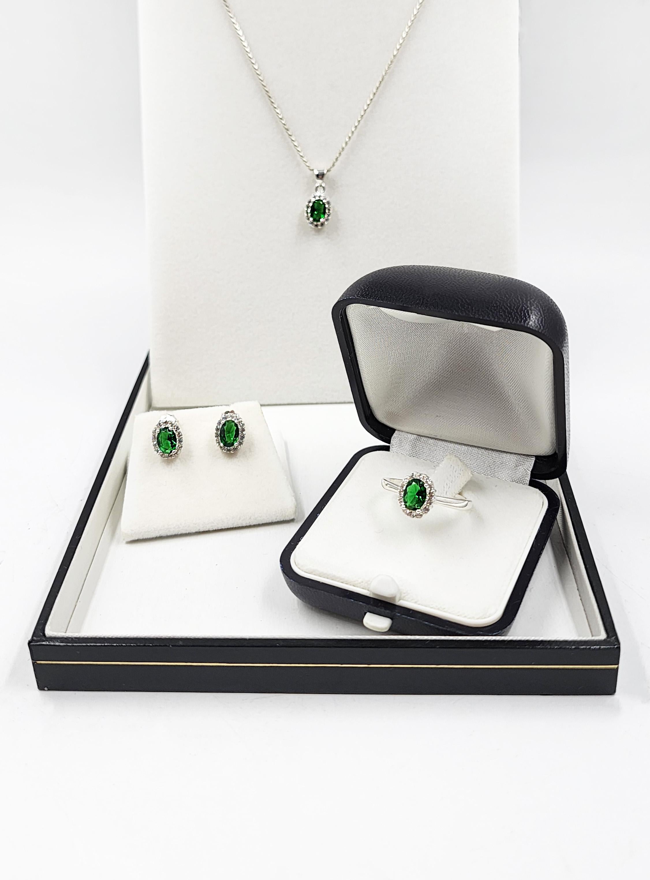 Vintage Silver Necklace, Earrings, and Ring Set
This vintage-style jewelry set features a necklace, a pair of earrings, and a ring. Each piece is crafted of silver and adorned with a central oval-cut synthetic emerald, highlighted by its intense