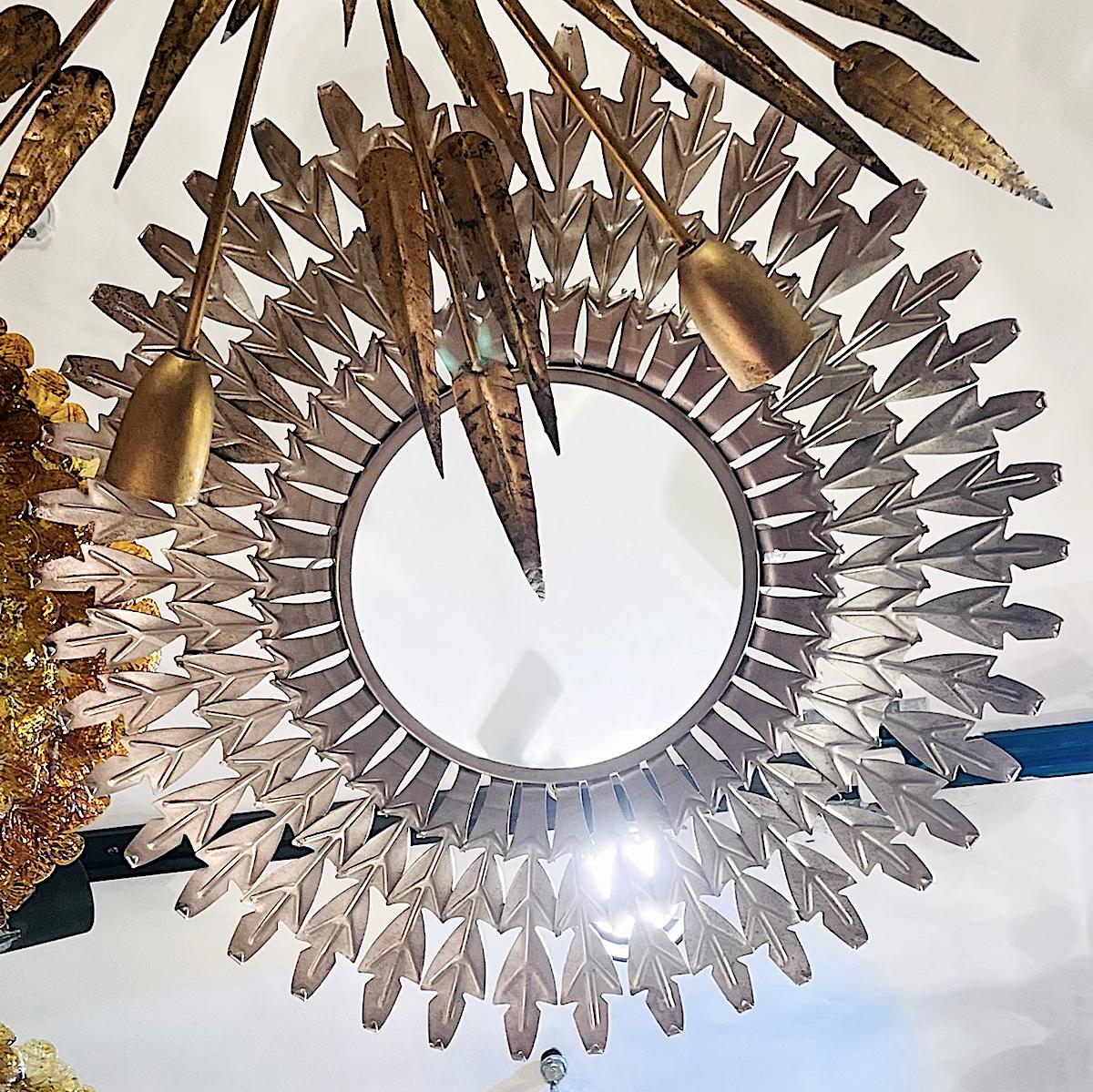 A circa 1950's silver plated sunburst shaped light fixture with 4 interior lights.

Measurements:
Drop: 11