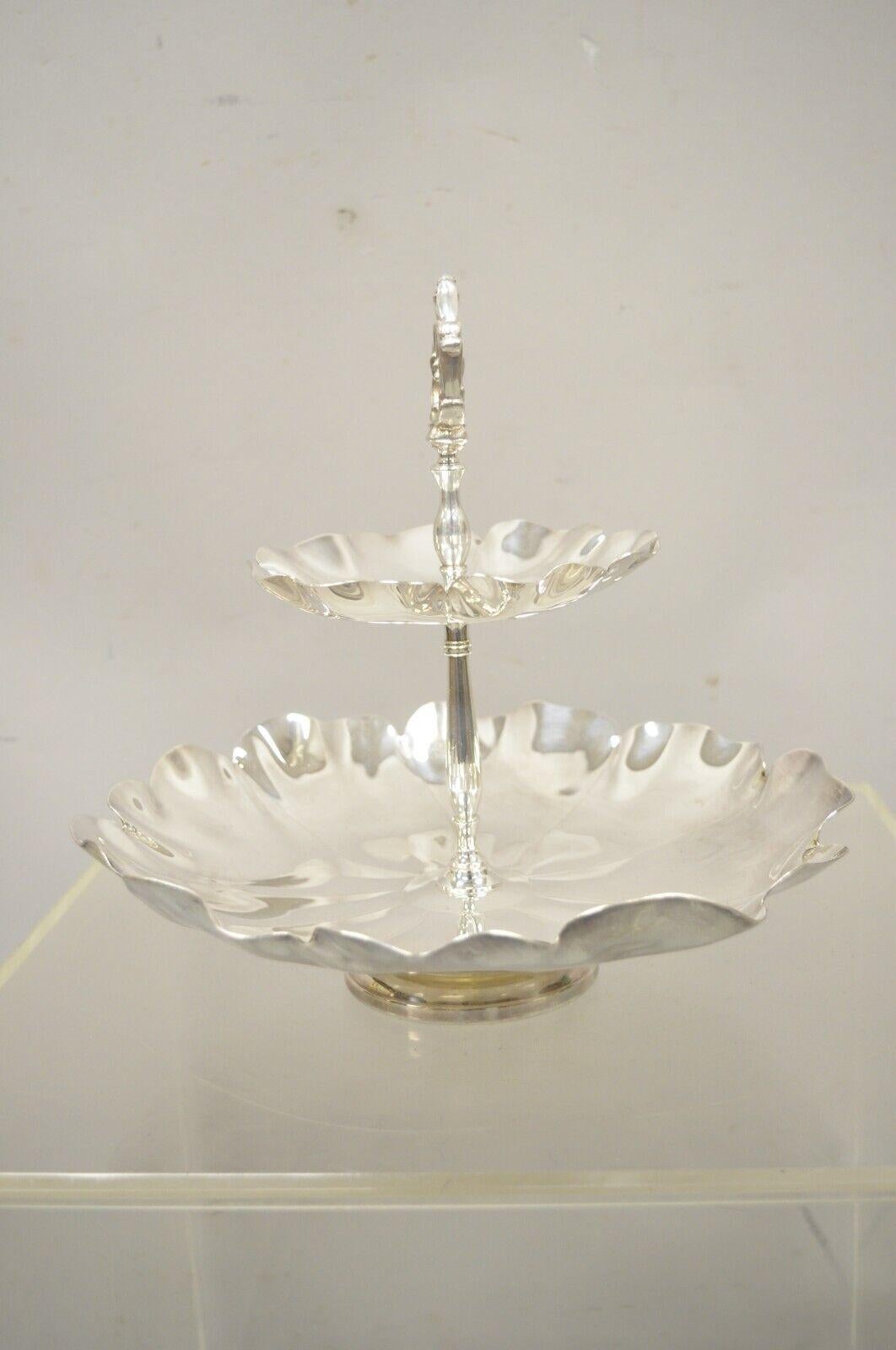 Vintage silver plate 2 tier scalloped edge candy dish display stand. Item features shield, crown, and 