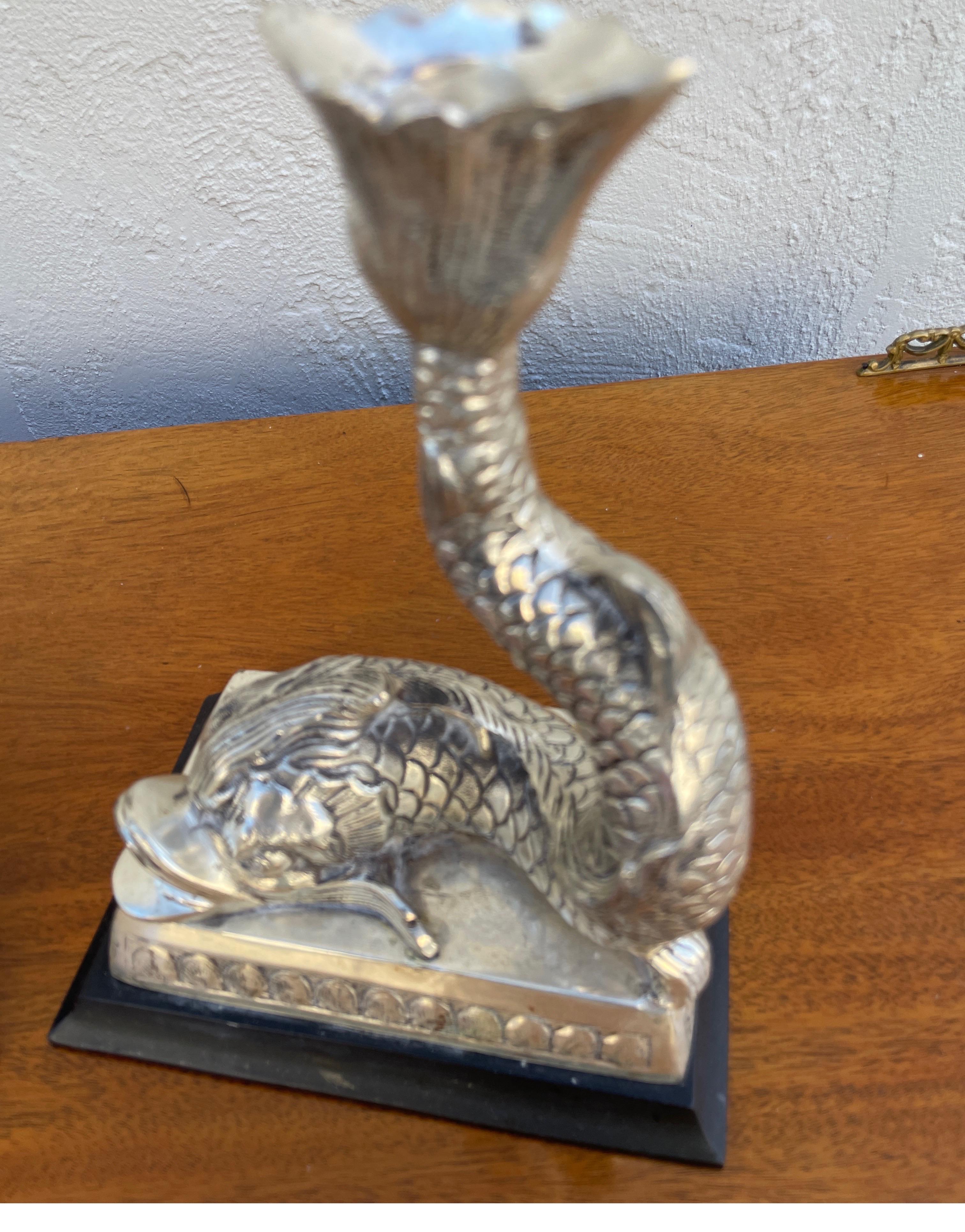 Vintage pair of silver plate opposing Dolphin candlesticks. A lovely addition to any table setting.