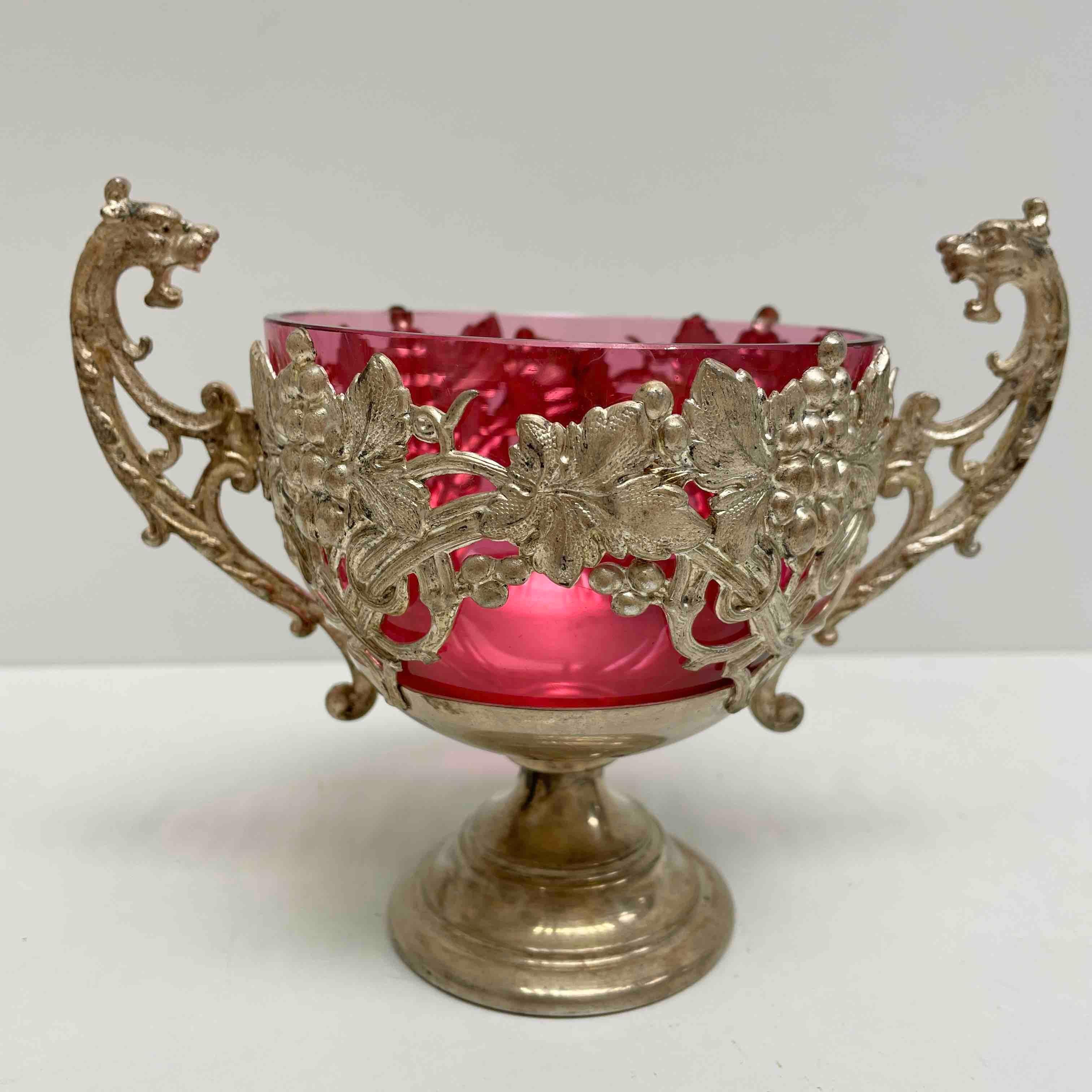Gorgeous silver plated, 1910s bowl or catchall. Made of silver plated metal frame with dragon handles and a pink glass. Think it can be used at a table for paperclips, toothpicks, matchsticks or just as an open salt pot or to store everything you