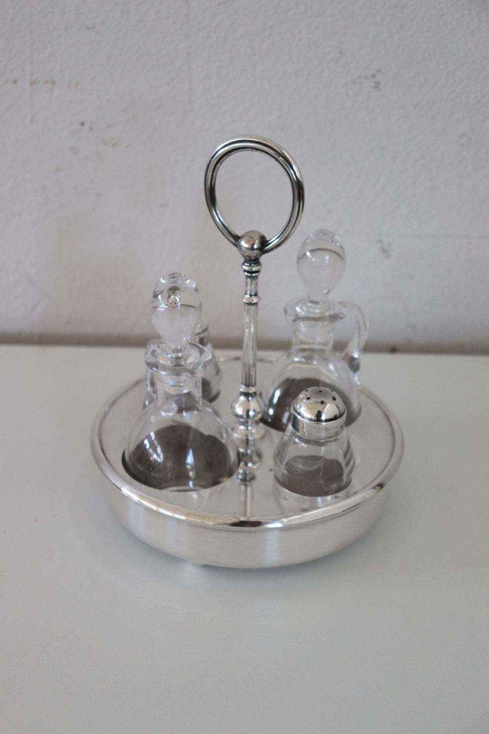 Beautiful silver plate condiments set consisting of a salt holder, a pepper holder, a bottle for oil and a bottle for vinegar. Mark Fleuron, Christofle France. Perfect for embellishing a table with class.