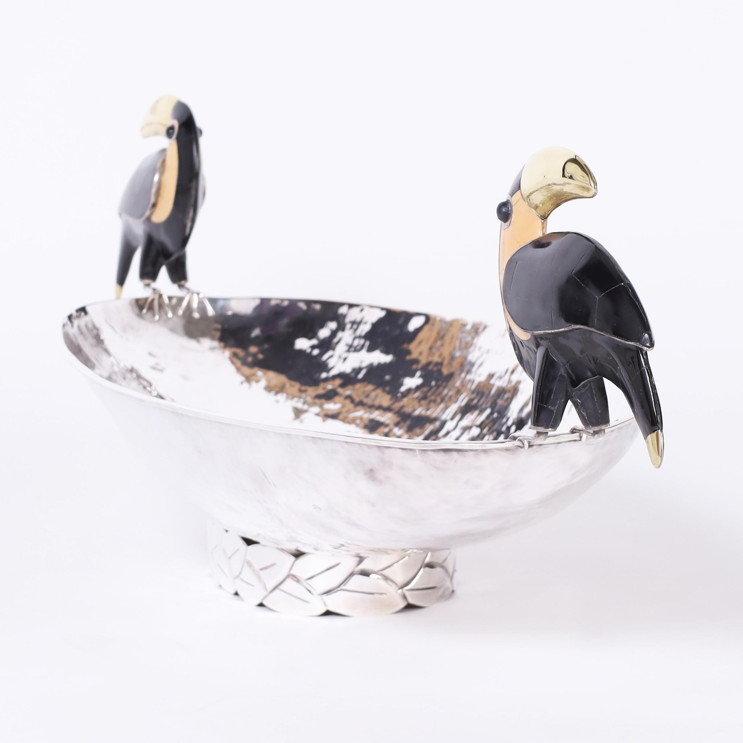 Striking Mid Century Art Deco style long bowl handcrafted in silver plate over hammered copper in dramatic form having two stone clad toucans as handles and stylized deco foot. Signed Emilia Castillo on the bottom.