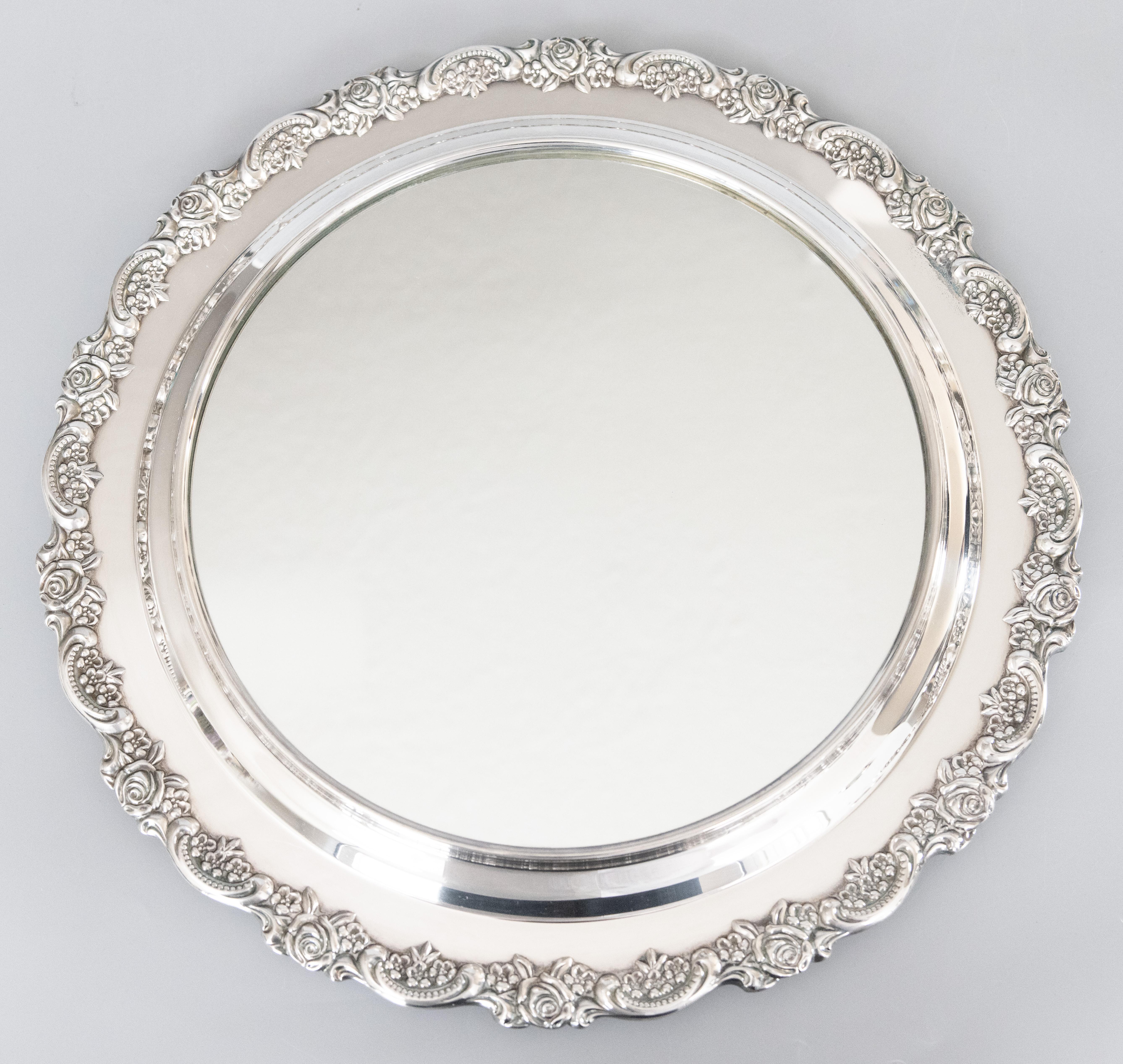 A superb vintage silverplate round mirrored table plateau or footed tray with an ornate floral roses border and charming ball feet, circa 1950. No maker's mark. It would look gorgeous displayed on a buffet with wine glasses, used to elevate a table
