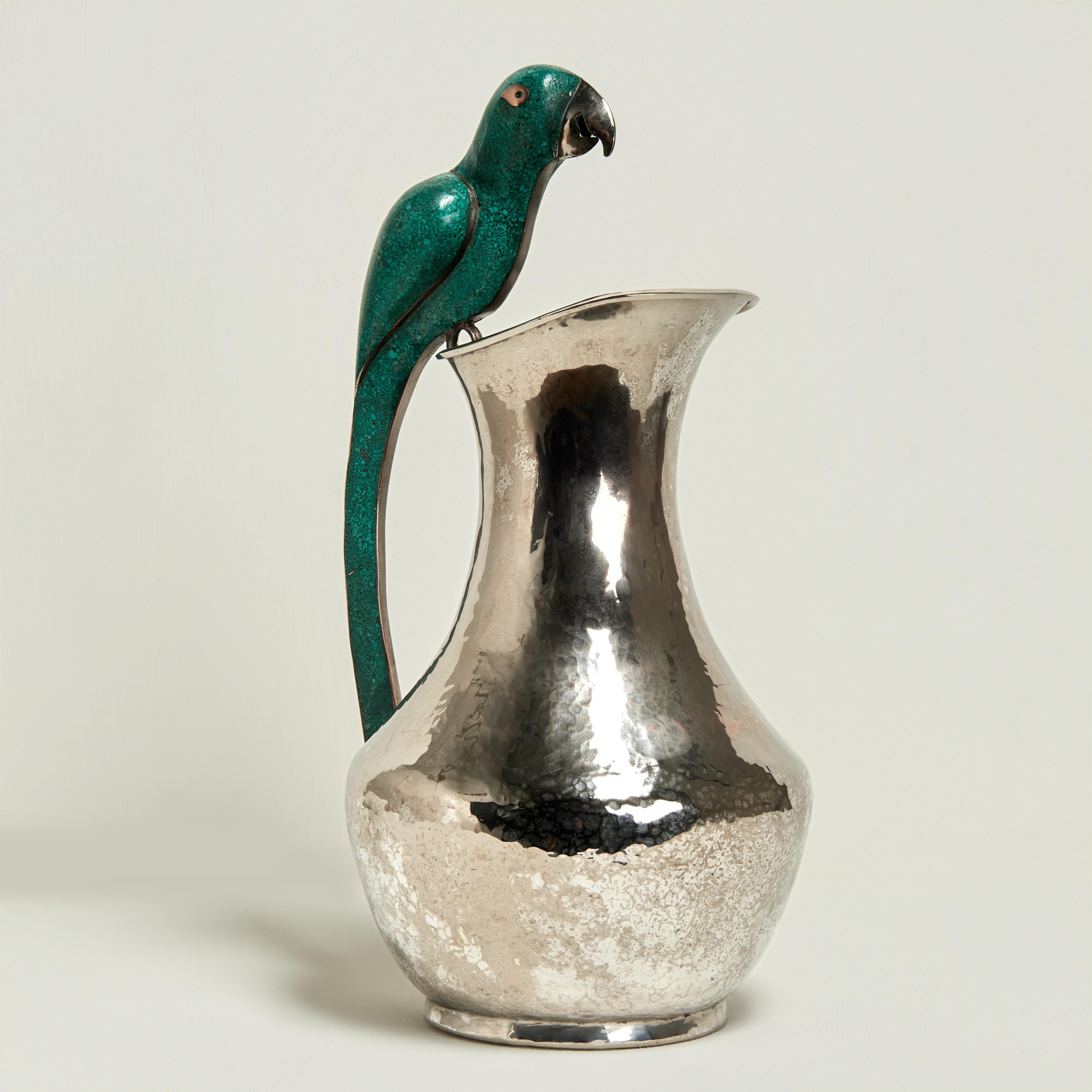Standout mid century pitcher handcrafted in silver plate on hammered copper in classic form featuring a stone clad parrot as a handle. Stamped Villasana Mexico on the bottom.