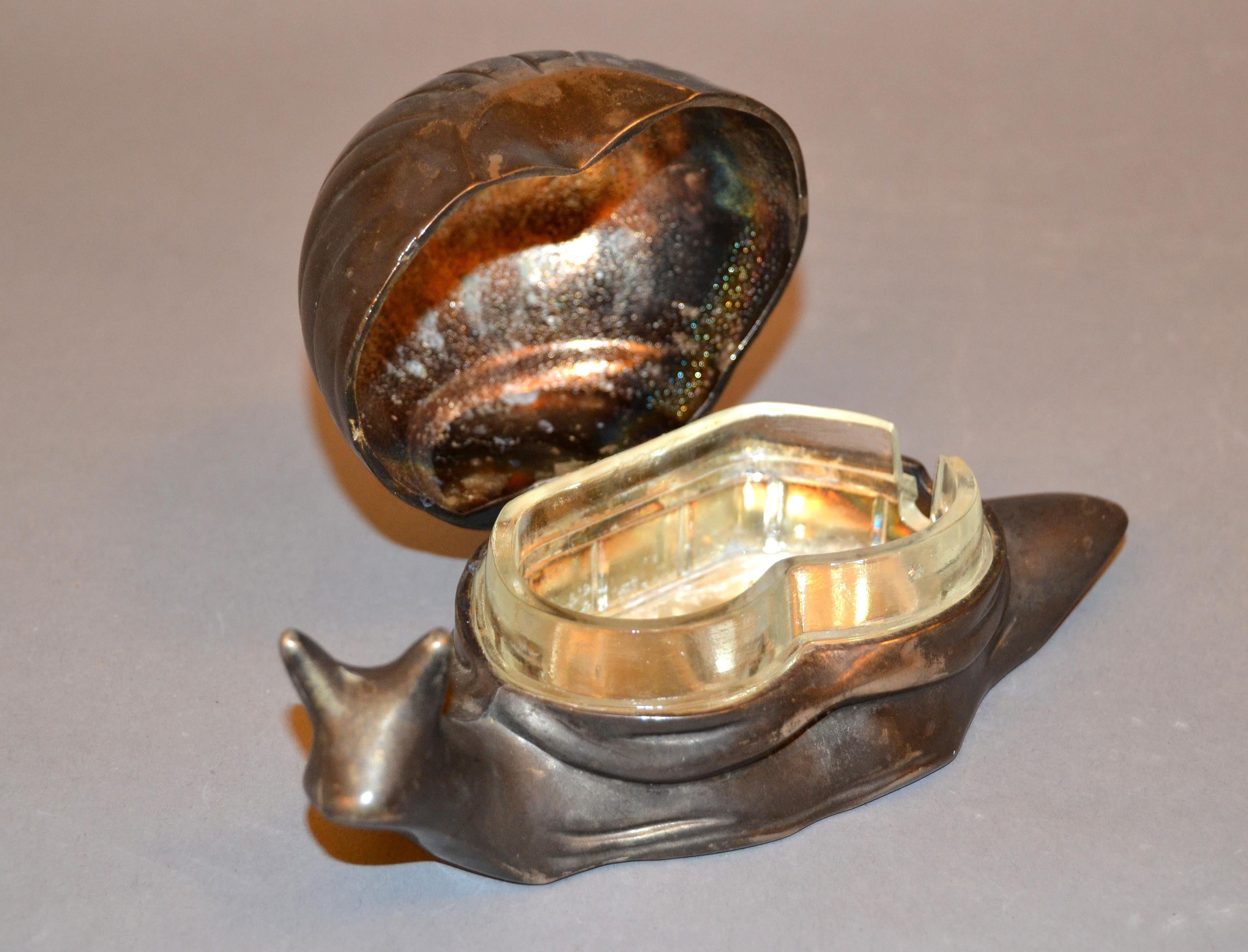 A vintage salt or spice dish designed as a snail with a glass tray inside.
Label silver plated on the bottom. 
Makes the perfect timeless gift!