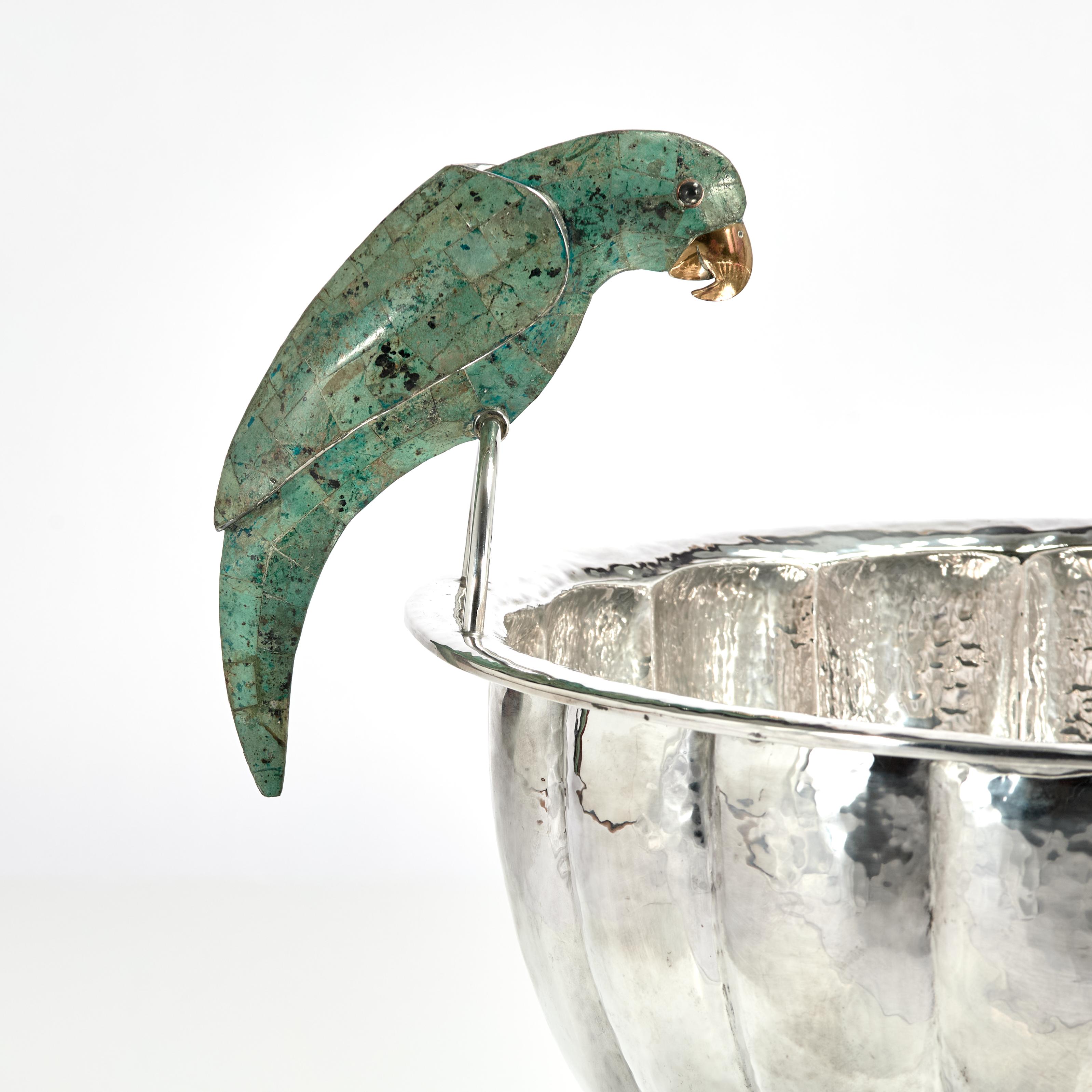 Standout large mid century footed bowl or wine cooler handcrafted in silver plate on hammered copper in a pleated form featuring two stone clad parrots as handles. Stamped Emilia Castillo on the bottom. 