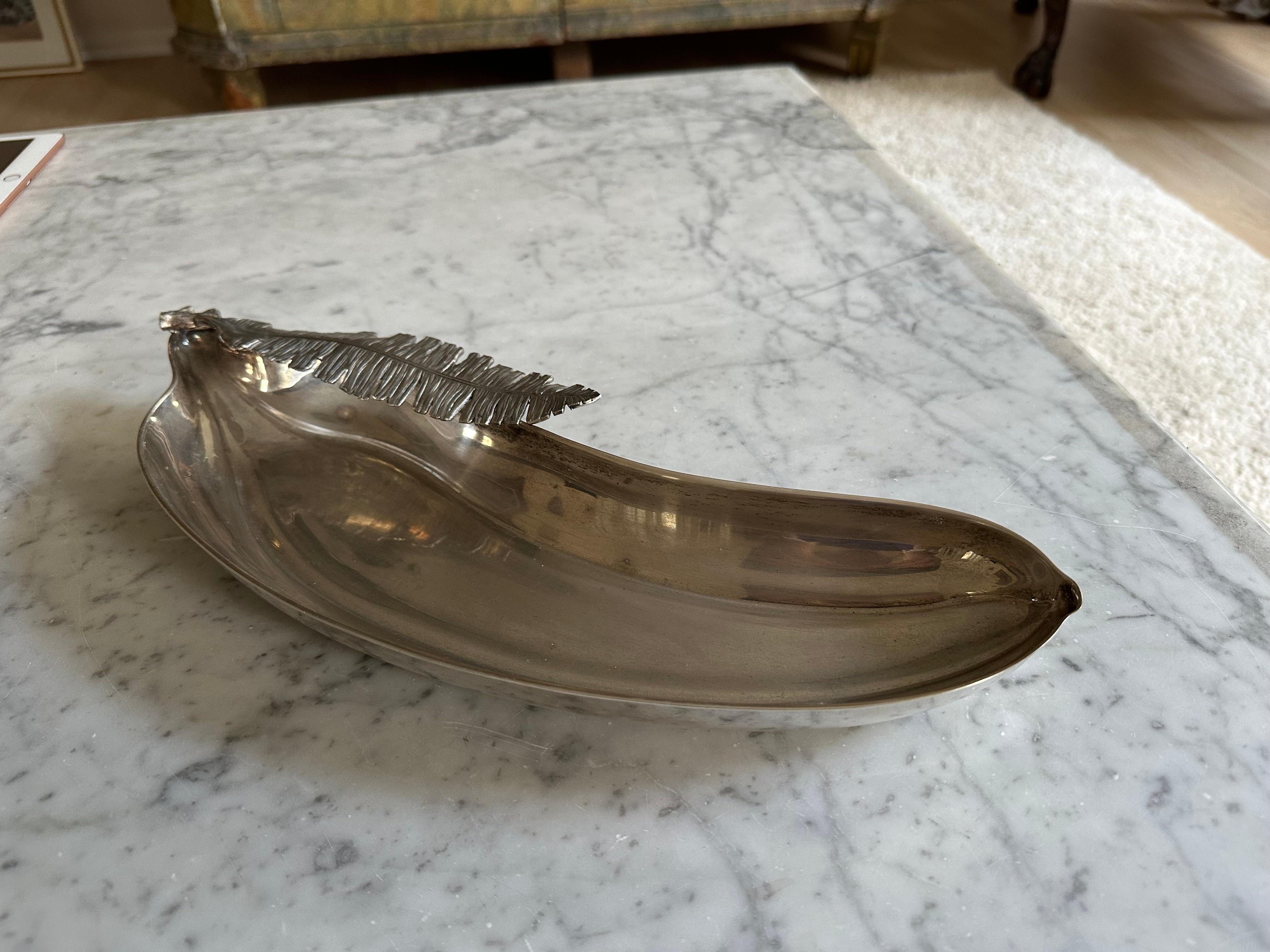 Diese einzigartige Vintage-Schale aus versilbertem Metall in Form einer Banane mit einem strukturierten Bananenblattmuster ist ein auffälliges Dekorationsstück aus den 1970er Jahren. Durch sein vielseitiges Design eignet er sich ideal als