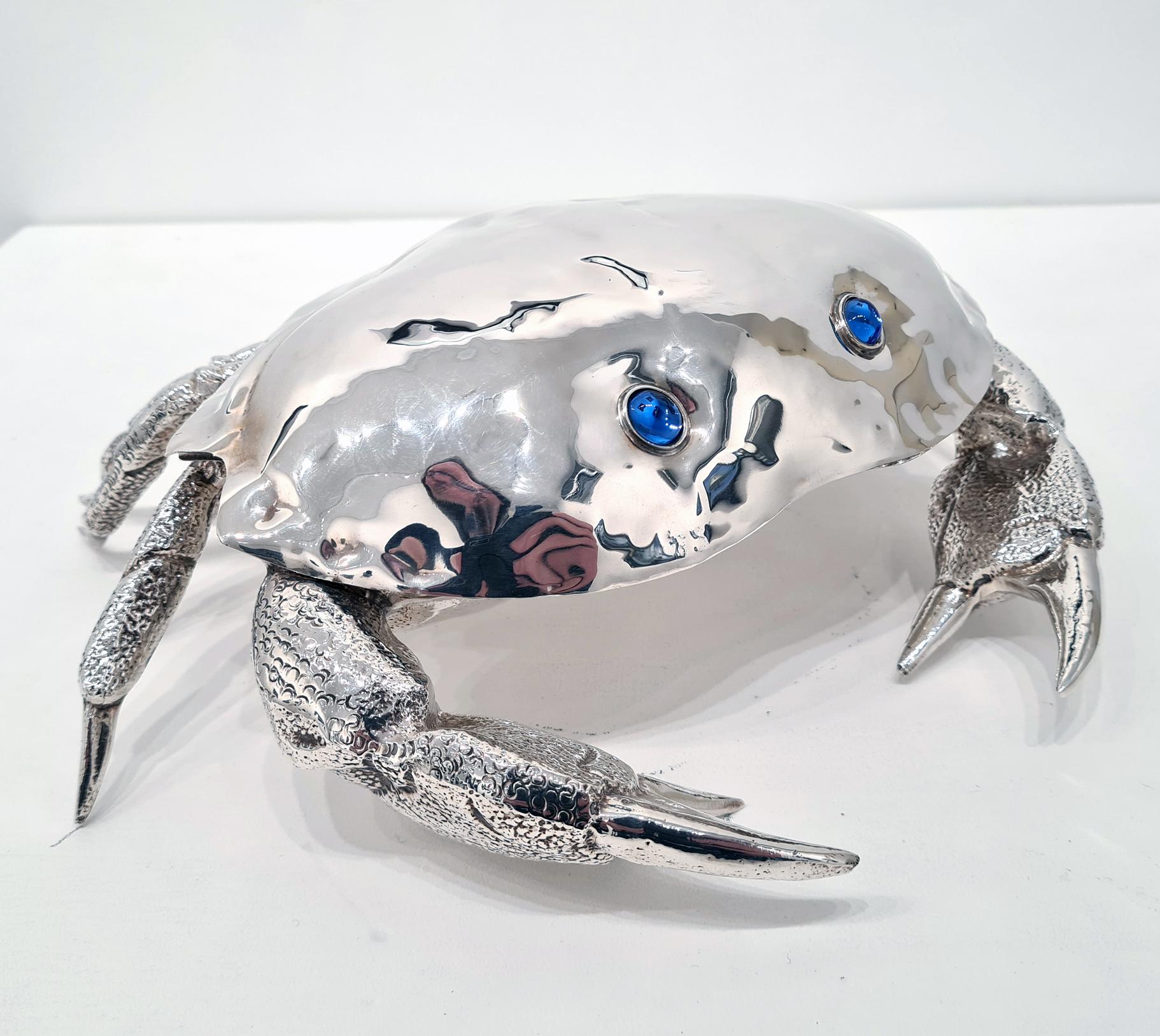 A silver-plated caviar dish in the shape of a crab, made by Almazan in Spain c. 1970. 

The crab is excellently modelled, with fine attention to detail in the legs and claws. The original inset glass bowl for the caviar is a rich sapphire blue, and