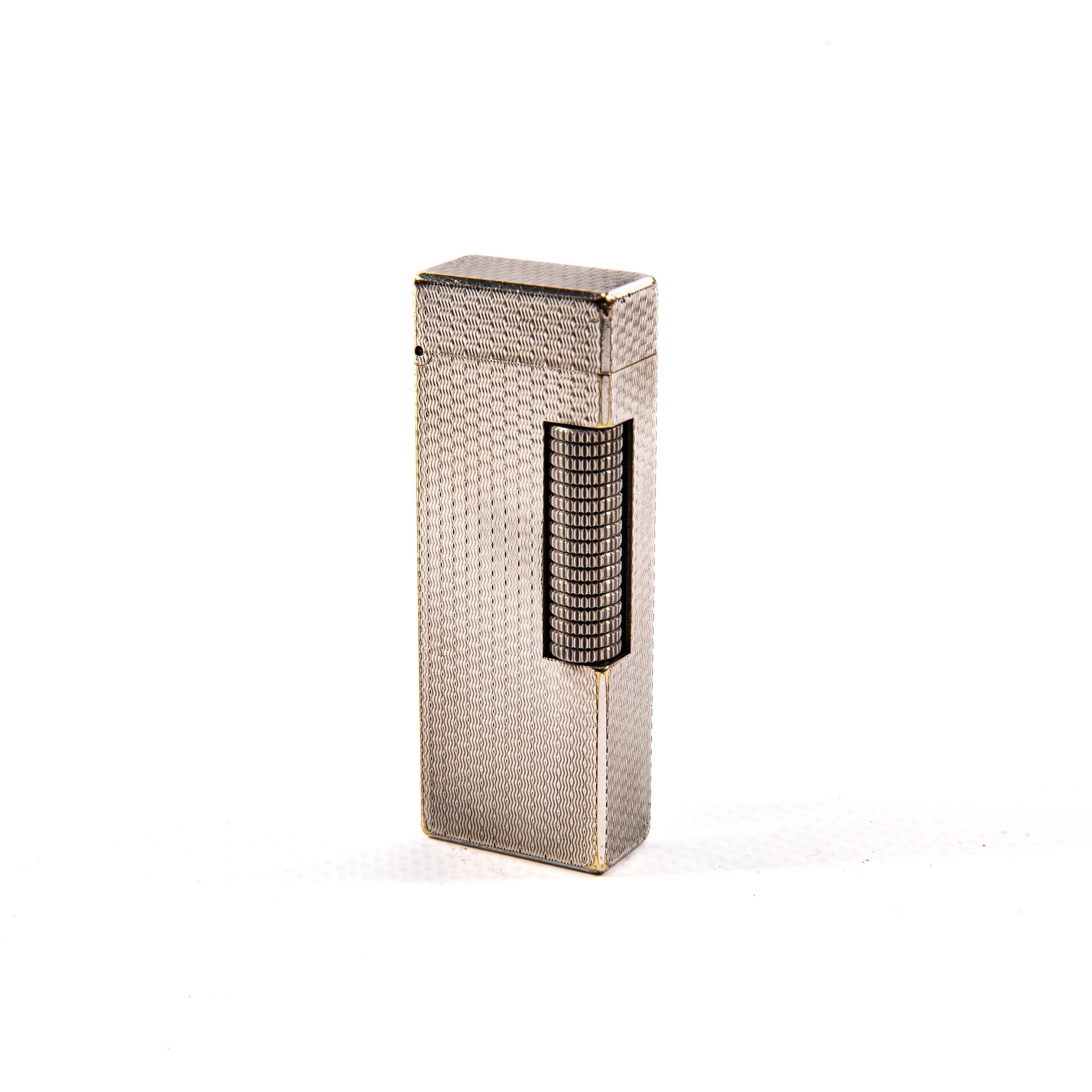 Dunhill, un marchio sinonimo di quintessenza dell'eleganza britannica, produce accendini fin dagli anni '20, rinomati per il loro impegno nella qualità e nel lusso sobrio. L'accendino Dunhill Rollagas, introdotto per la prima volta negli anni '60,