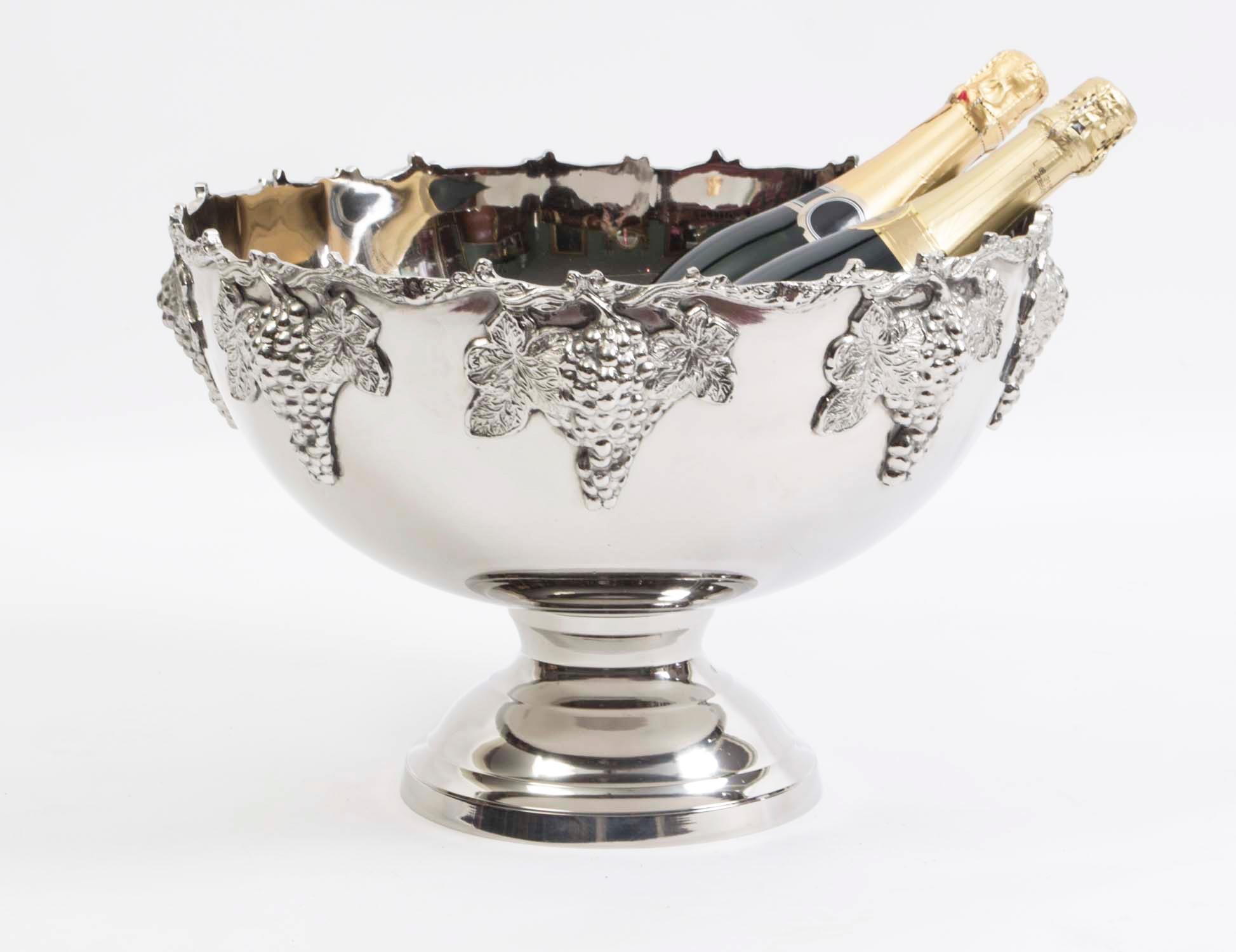 This is a gorgeous vintage silver plated Monteith champagne cooler dating from he late 20th C.

Around the top of this exquisite punch bowl are bunches of grapes that are connected by twisting vines which are flanked by leaves. This beautiful