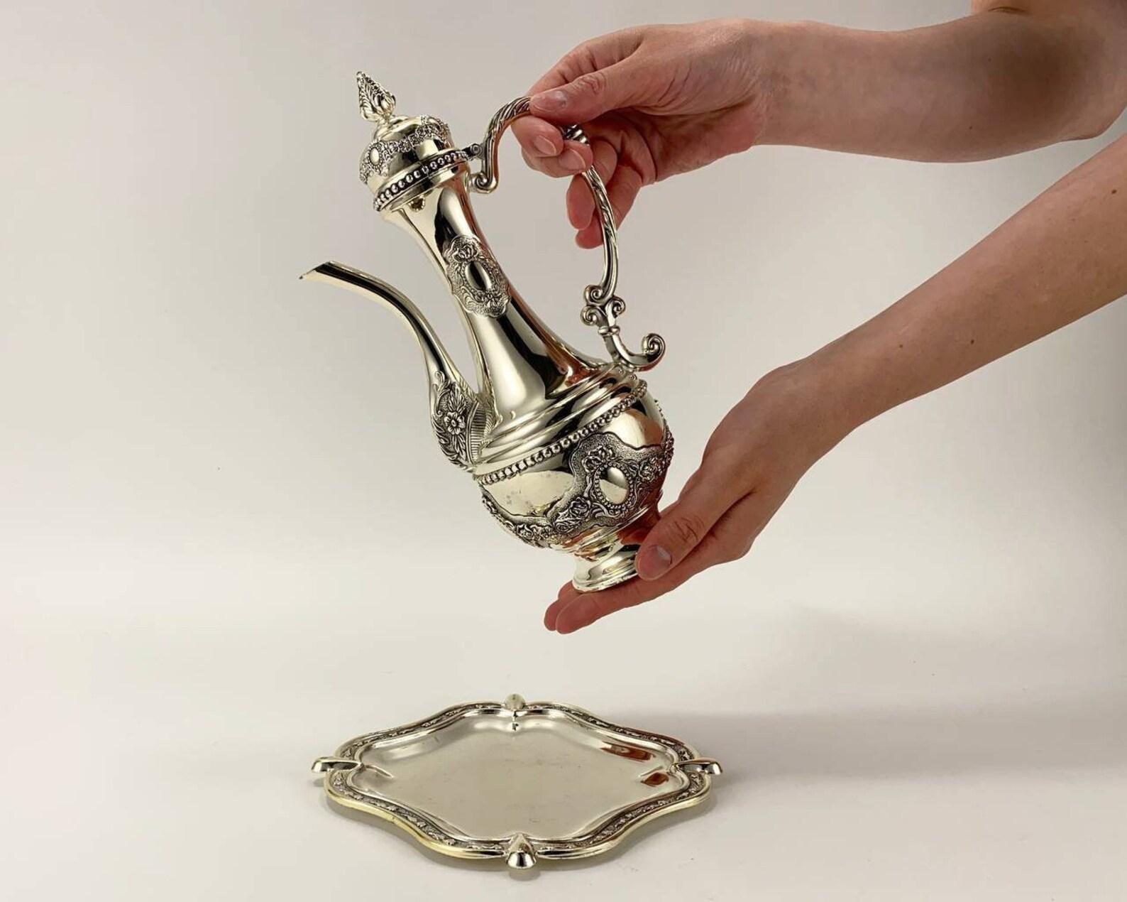 Vintage Silver-Plated Teapot on a Tray. 

  A jug with a narrow neck and spout is most suitable for serving strong drinks. In a silver vessel of this form, the drink will retain its qualities and properties well, will not expire and it is convenient